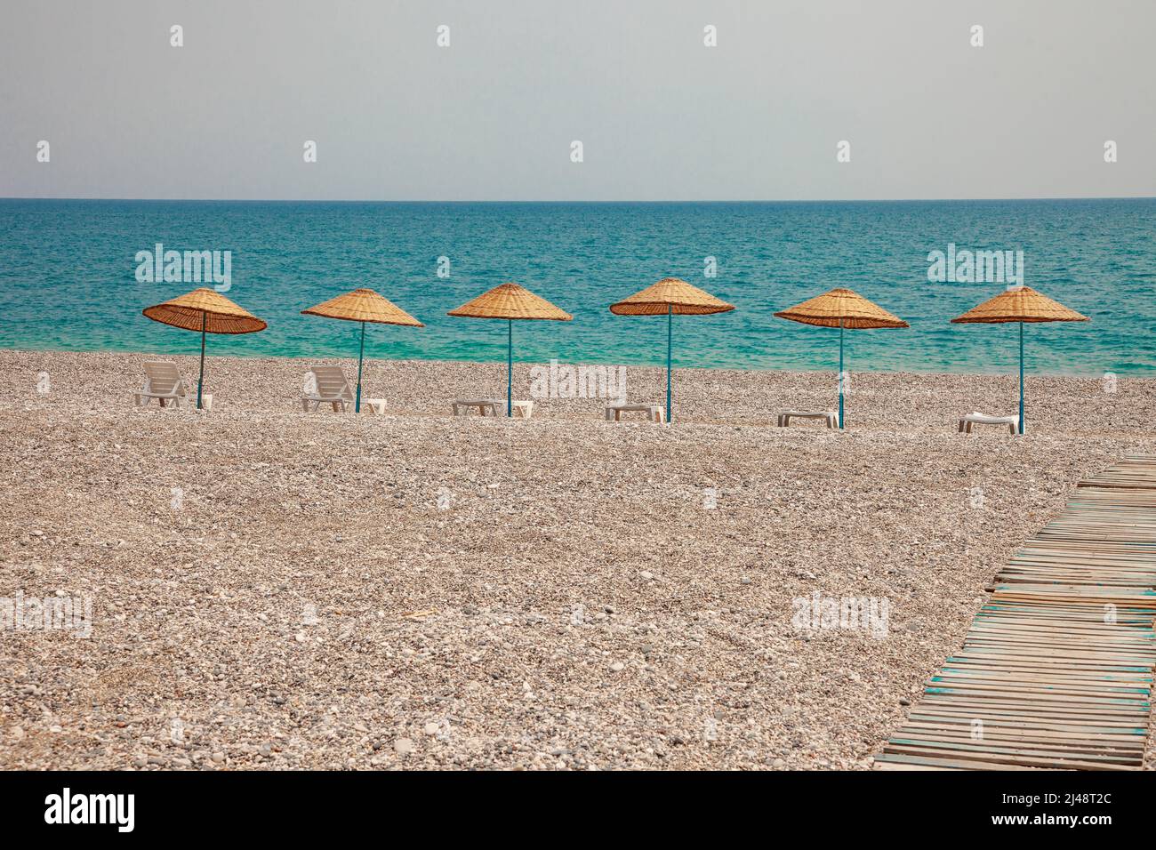 Ombrelloni da spiaggia e chaise longue sulla costa Foto Stock