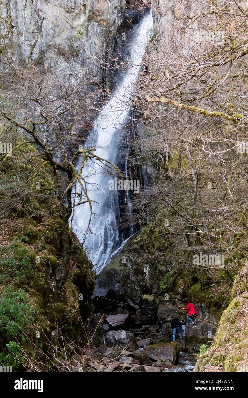 Persone che camminano lungo un sentiero scivoloso che porta alla Taglia di Gray Mare, una delle cascate più impressionanti in Scozia, Regno Unito Foto Stock