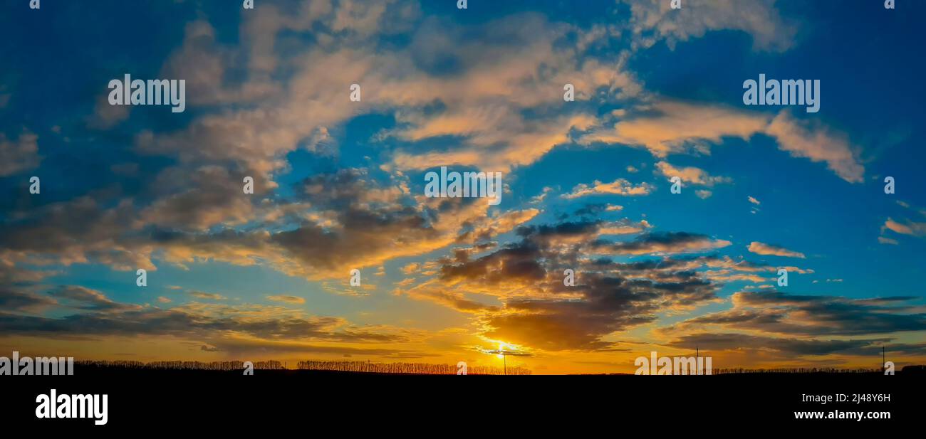 Panorama del cielo con tramonto. Nuvole arancioni. Foto Stock