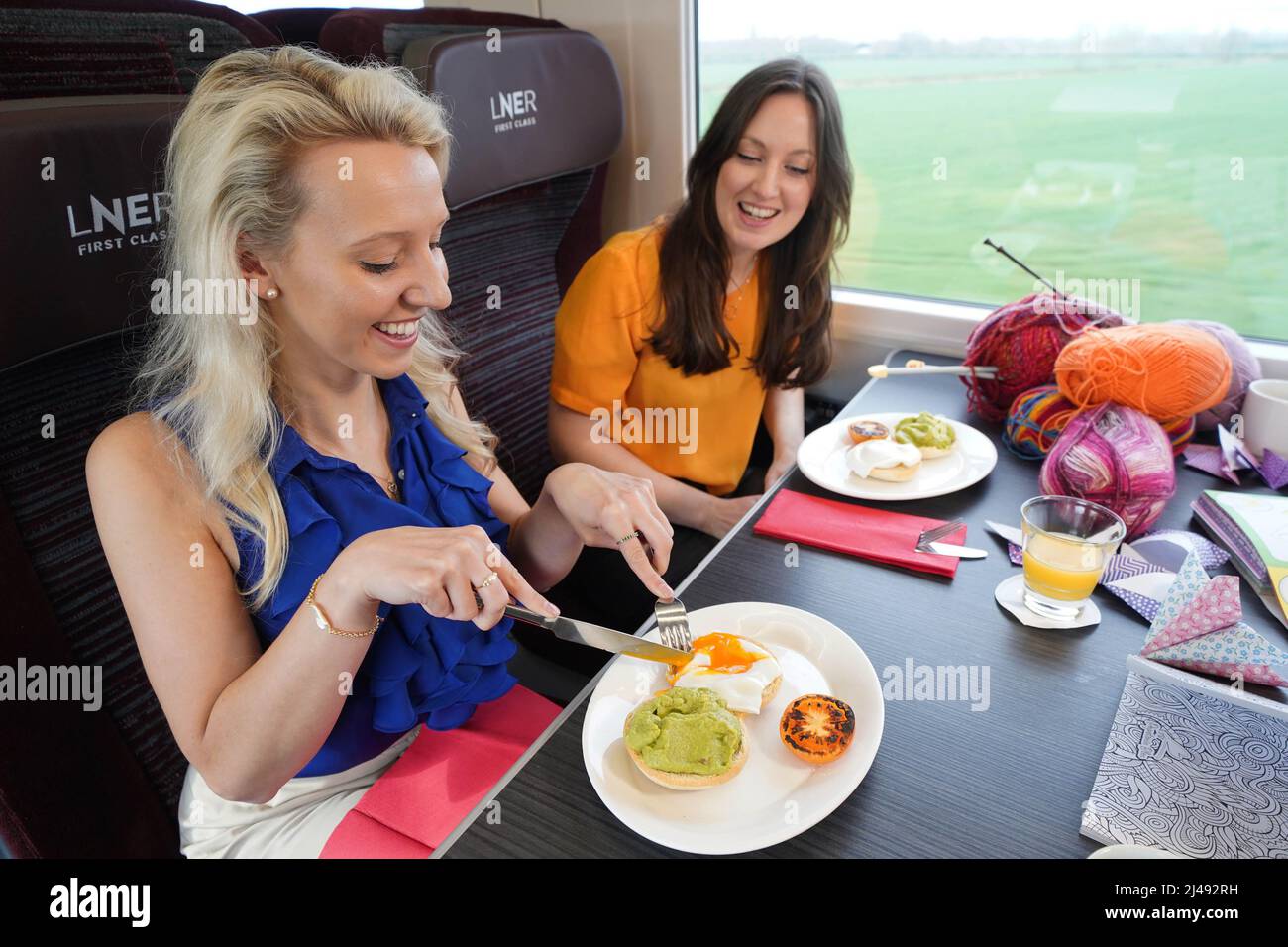 USO EDITORIALE SOLO i clienti Lorna e Joanne mangiano da un menu su misura, durante una speciale anteprima di ciò che sarà disponibile a bordo del treno benessere London North Eastern Railway's (LNER), Che si terrà il 08:06 London King's Cross to Lincoln servizio Sabato 7 maggio, segnando l'inizio della settimana di consapevolezza Salute mentale. Data di emissione: Mercoledì 13 aprile 2022. Foto Stock