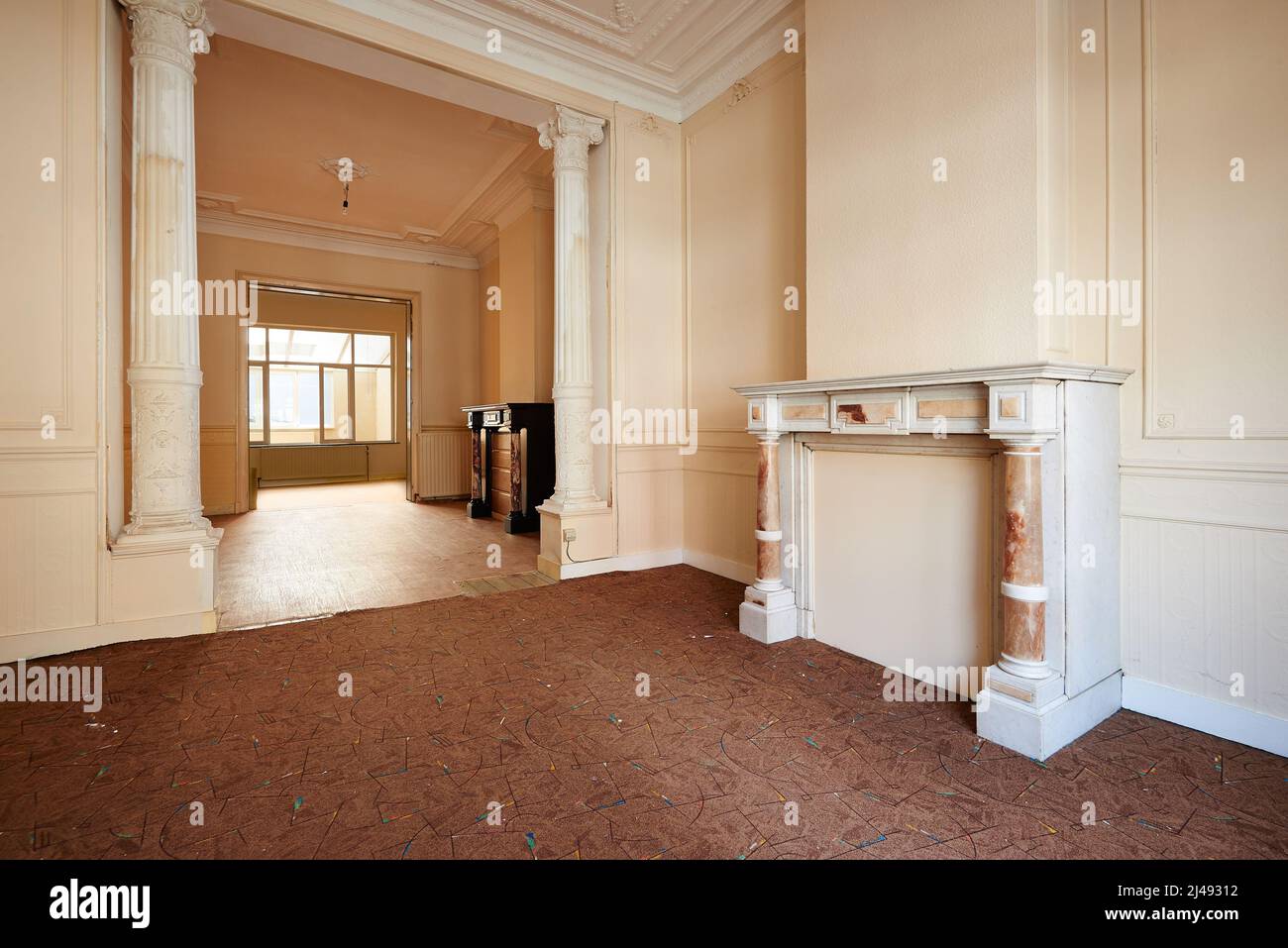 Appartamento vuoto con due caminetti classici in prospettiva e prima della ristrutturazione Foto Stock