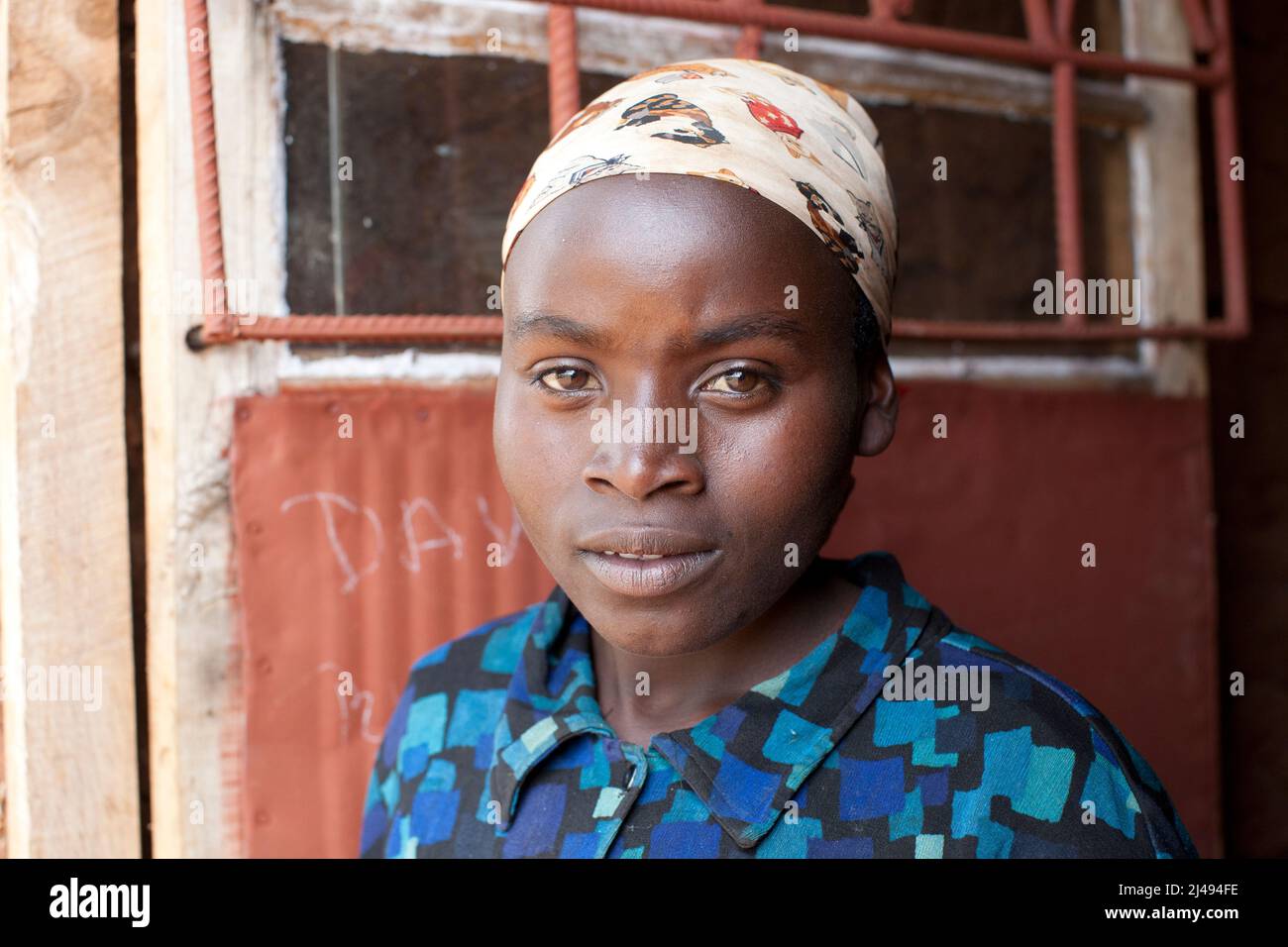 Olive Ikimpaye, 18, figlia di Paskazi, che cantò. Paskazi Mukasangwa, 60 anni, madre di 7 bambini, è ora un operatore sanitario comunitario per la salute materna e nascente. Suo marito in prigione per 30 anni per crimini di genocidio, Mbazei settore, Huye disrict. Il coinvolgimento nel progetto le ha portato una mucca e ha aumentato significativamente la produttività della sua terra. Fotografia di Mike Goldwater Foto Stock