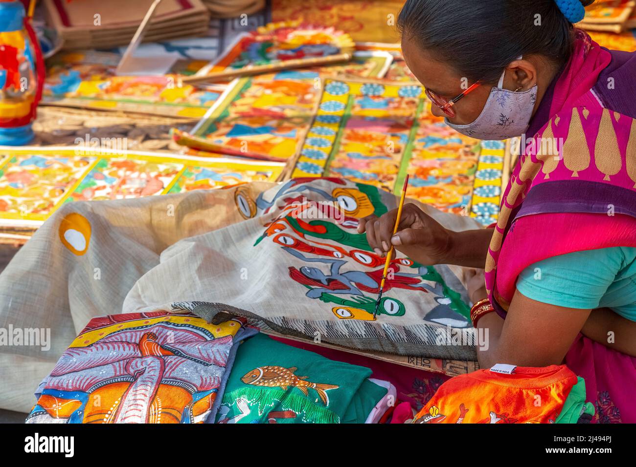 Artista donna che fa pittura di tessuto su un telaio a mano sari ad una fiera dell'artigianato a Kolkata, India Foto Stock