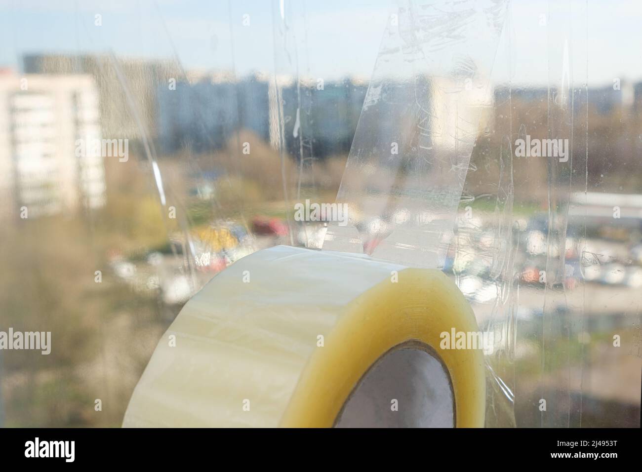 Sigillare le finestre con nastro adesivo durante la guerra in Ucraina per prevenire la formazione di molti frammenti durante l'ondata di esplosione Foto Stock