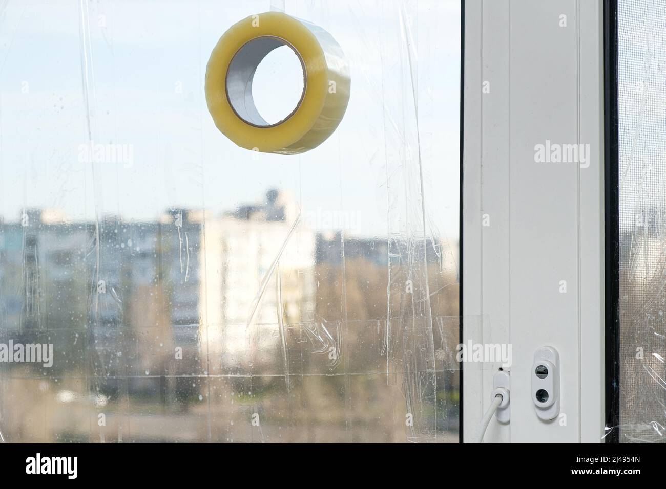 Sigillare le finestre con nastro adesivo durante la guerra in Ucraina per prevenire la formazione di molti frammenti durante l'ondata di esplosione Foto Stock
