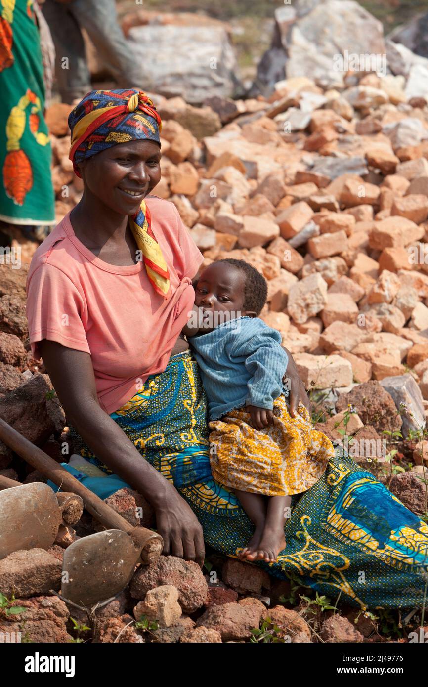 Ephrazia Nyirantezimamama con il suo Clarice Uwimama di un anno. Umuganda mensile servizio comunitario per la costruzione di aule per 12 anni di istruzione di base. La scuola Mwurire Groupe Scolare, Mbazí Sector, Huye District. Foto Stock