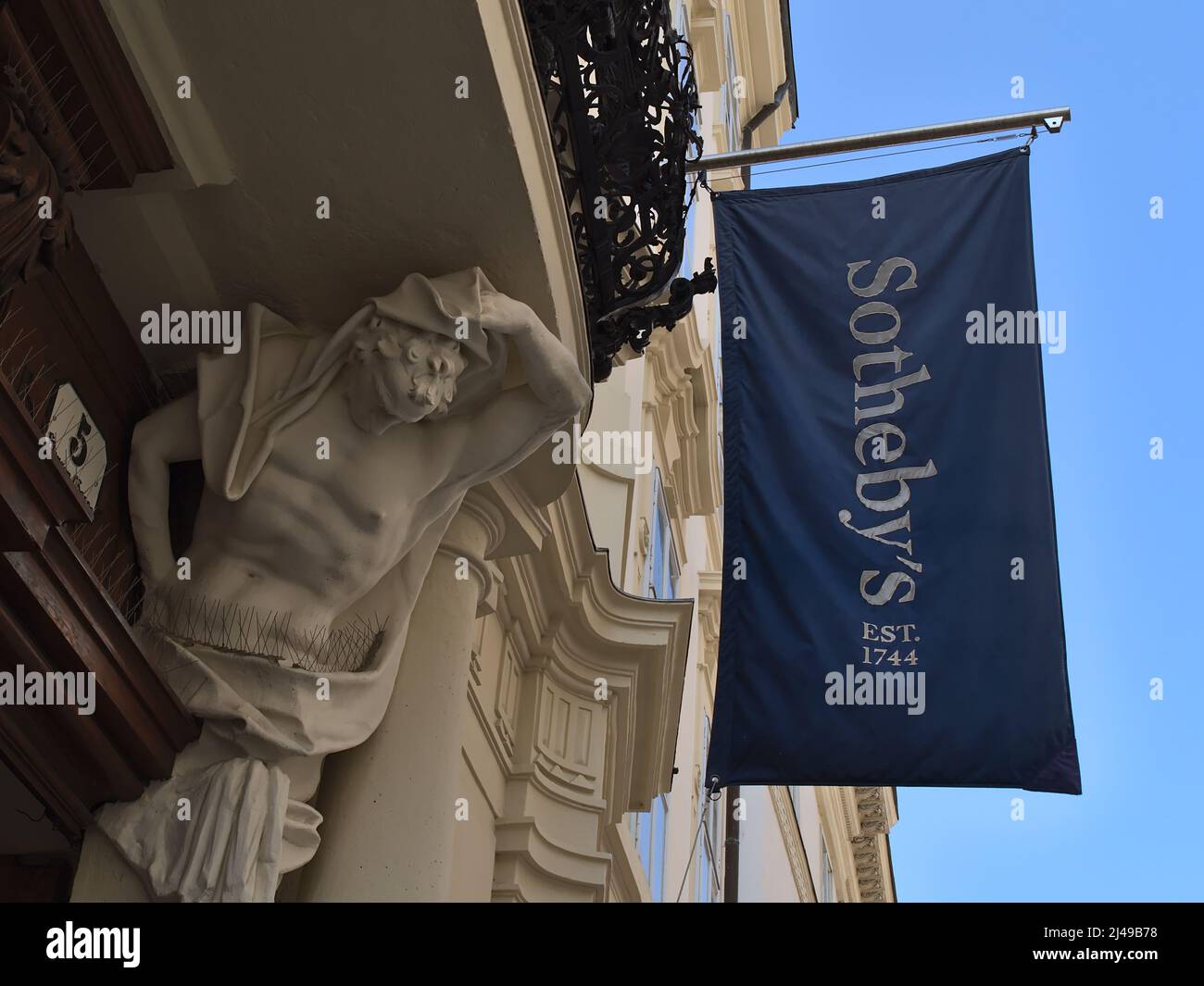 Vista ad angolo basso dell'ingresso dell'edificio della casa d'asta Sotheby's nel centro storico di Vienna, Austria con bandiera di colore blu con logo. Foto Stock
