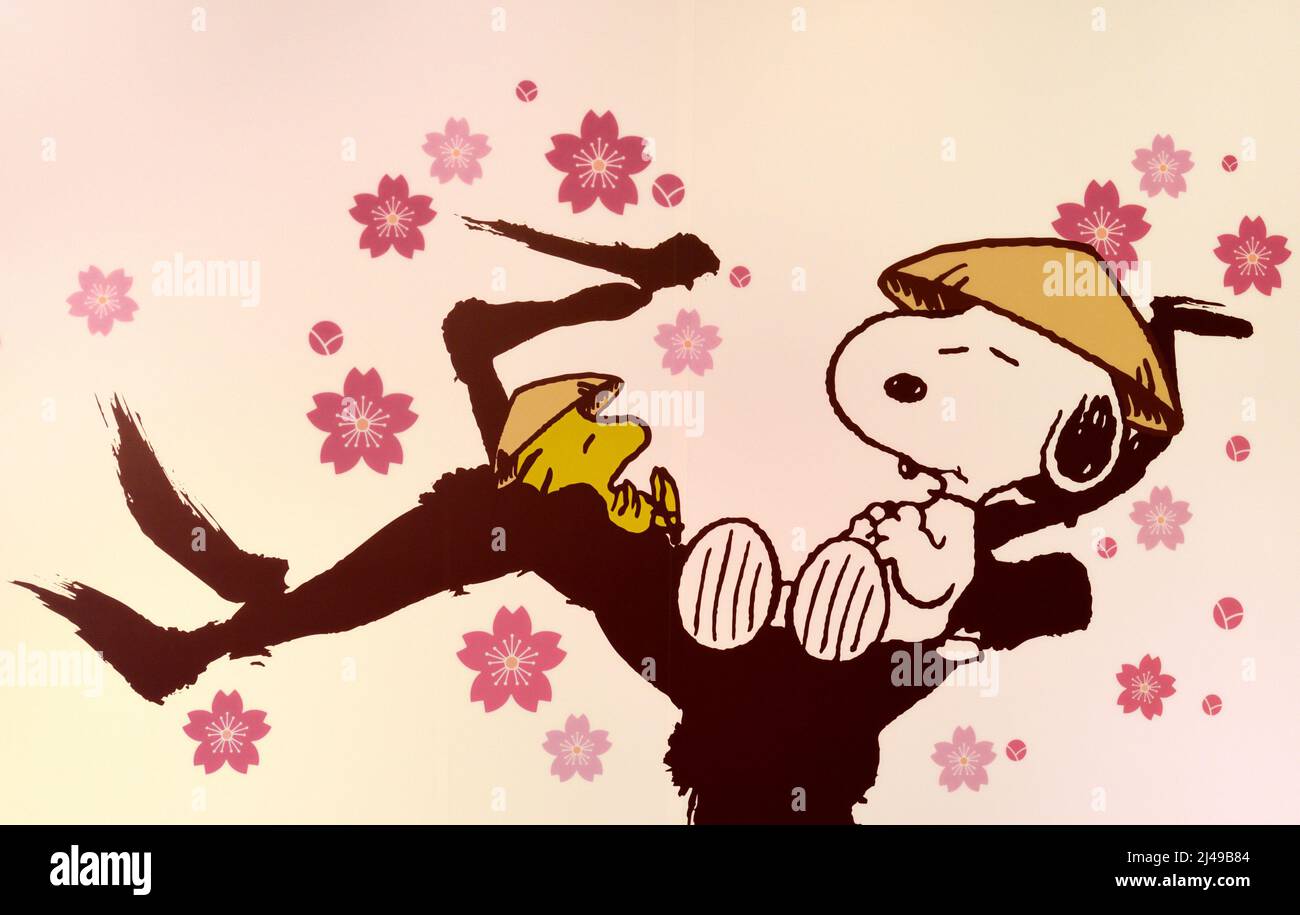 Snoopy e Woodstock che posano su fiore di pesca Foto Stock