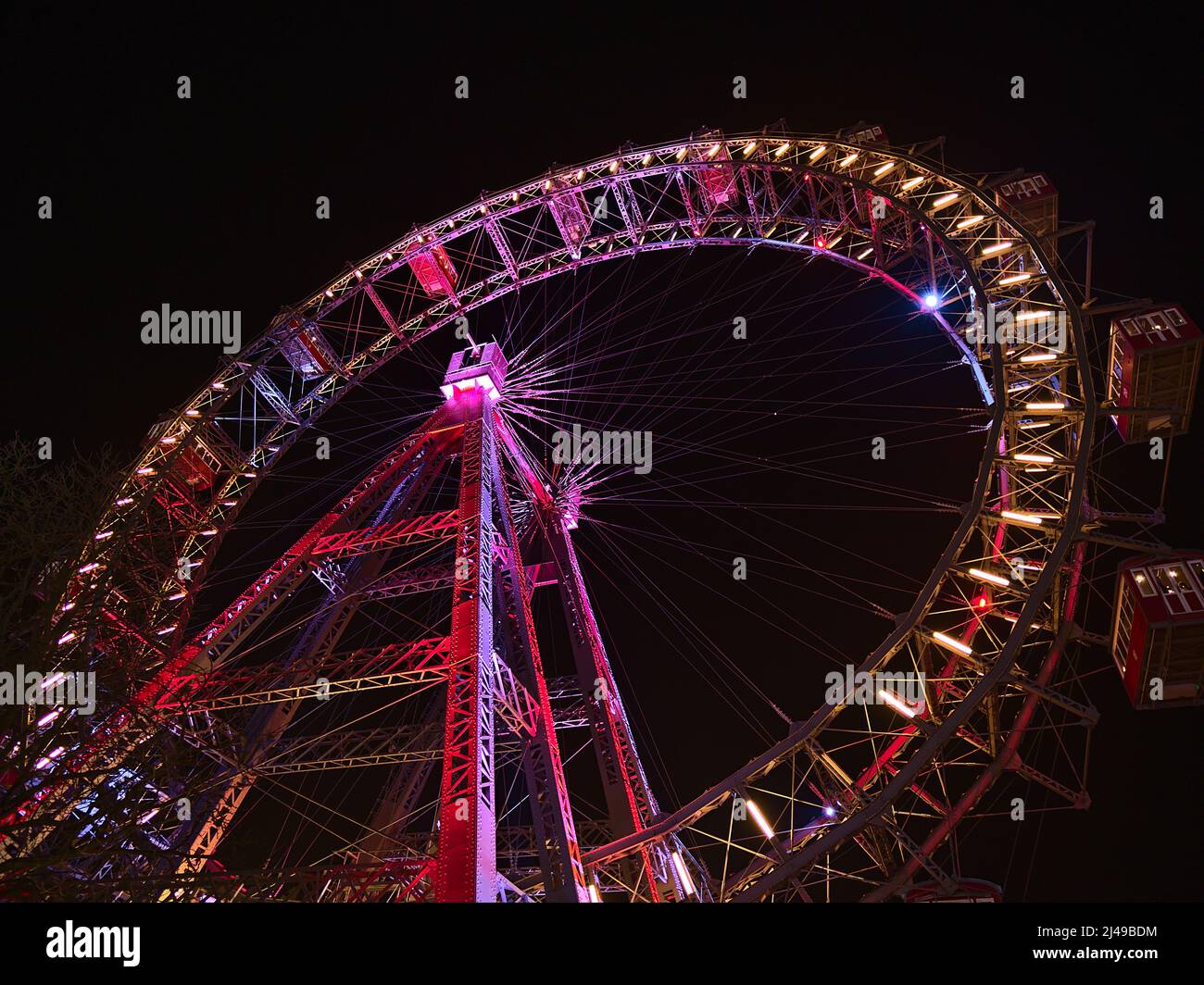 Vista ad angolo basso della famosa ruota di ferro Wiener Riesenrad, un'attrazione popolare nel parco divertimenti Wurstelprater a Vienna, Austria, con illuminazione. Foto Stock