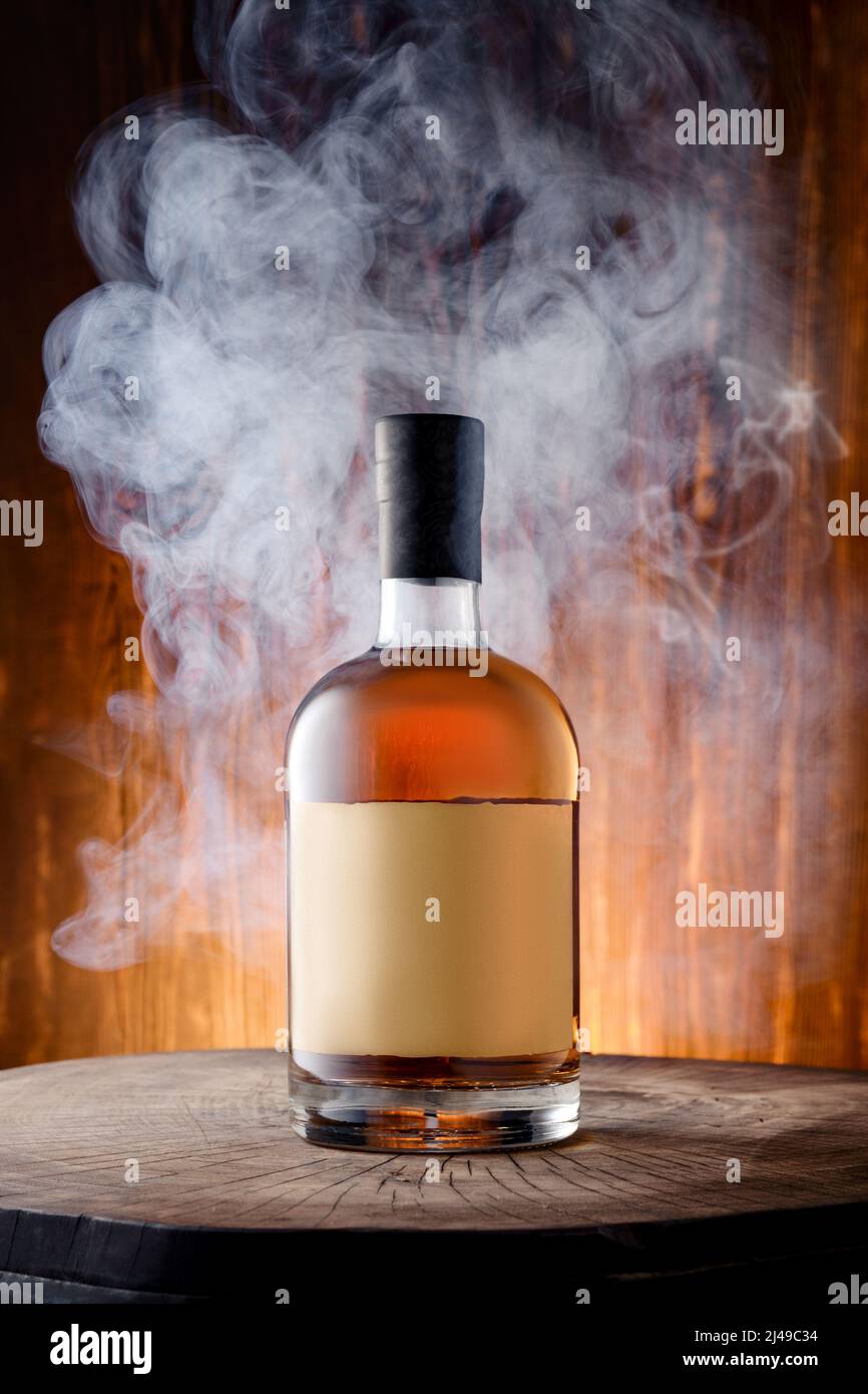Bottiglia di whisky scotch affumicato di malto misto circondato da fumo Foto Stock