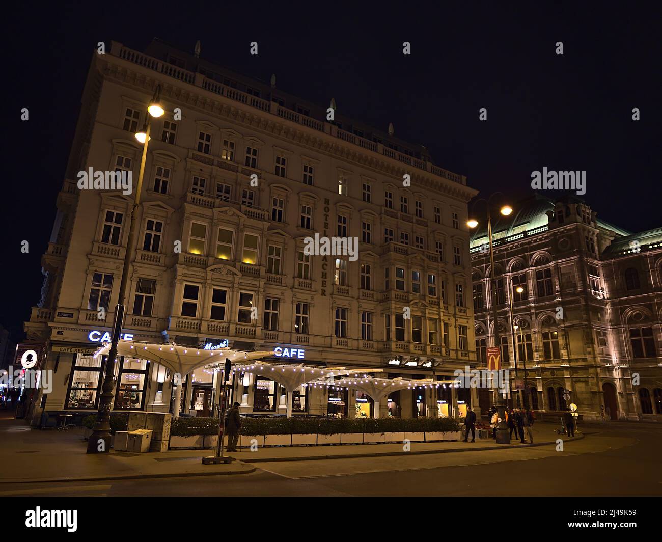 Vista notturna della famosa sistemazione di lusso Hotel Sacher nel centro storico di Vienna, Austria con facciata illuminata, Cafe Mozart e Vienna Opera. Foto Stock