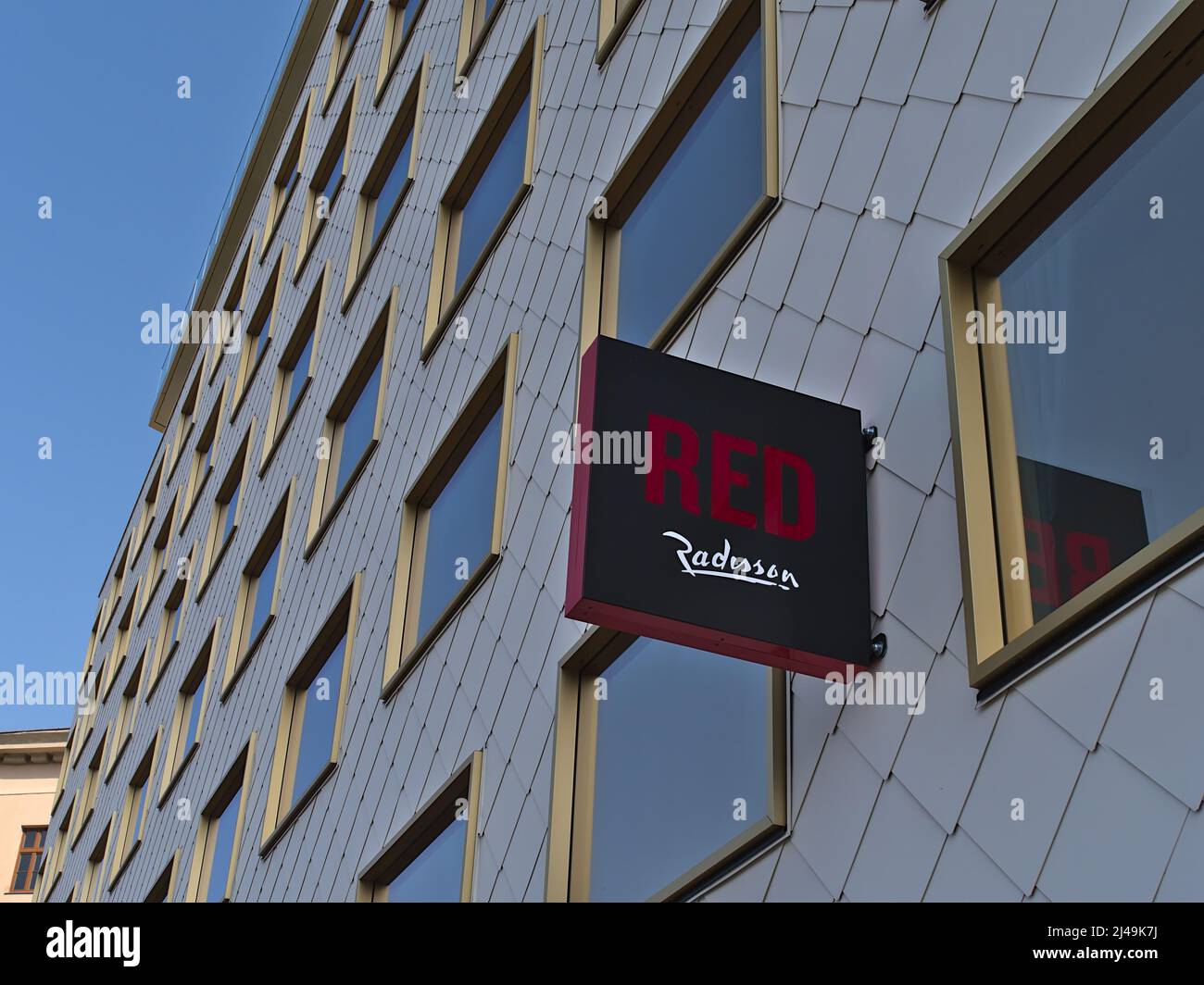 Vista ad angolo basso del cartello pubblicitario e del logo sulla facciata del nuovo hotel Radisson Red Vienna in Austria con riflessi nelle finestre del giorno di sole. Foto Stock