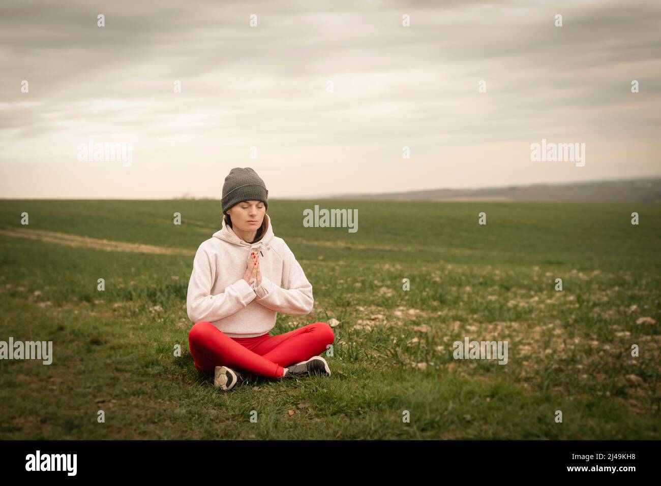 Donna seduta in lotus posa fare yoga all'aperto Foto Stock