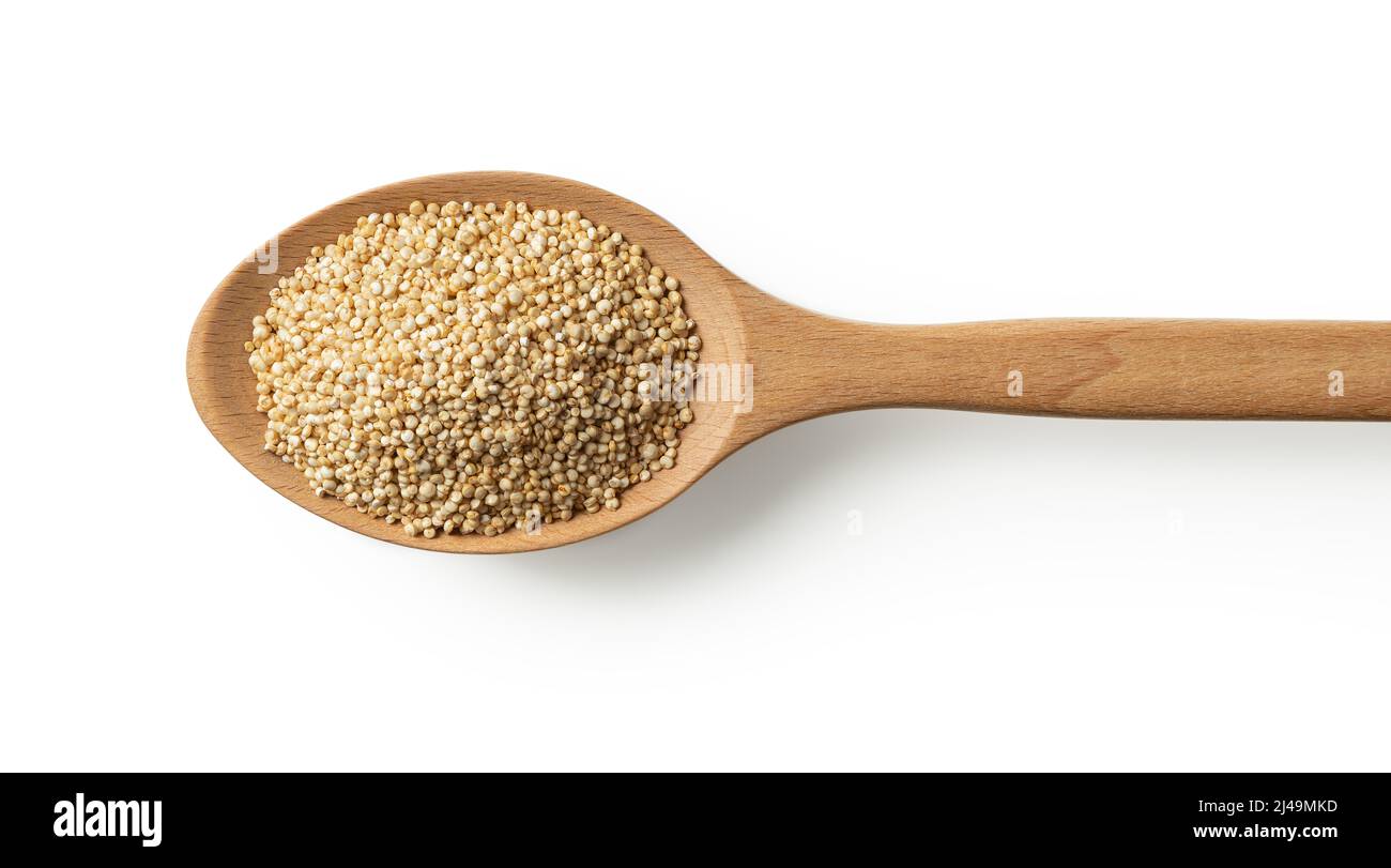 Grani di quinoa crudi in un cucchiaio di legno grande isolato su uno sfondo bianco. Cottura secco chenopodium quinoa macro. Superfood per la dieta senza glutine. Foto Stock