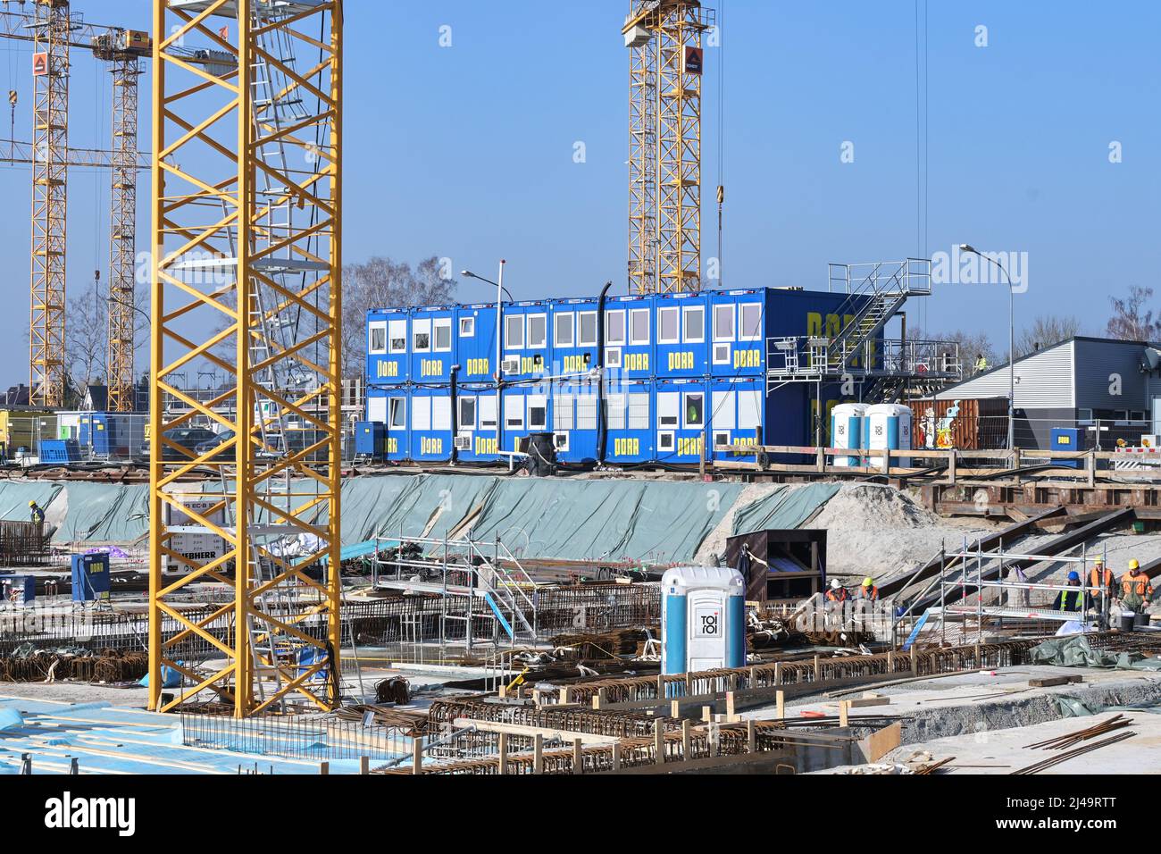 Lubeck, Germania, 3 marzo 2022: Container blu per uffici in un grande cantiere con fondazioni, rinforzi e gru per un nuovo edificio Foto Stock