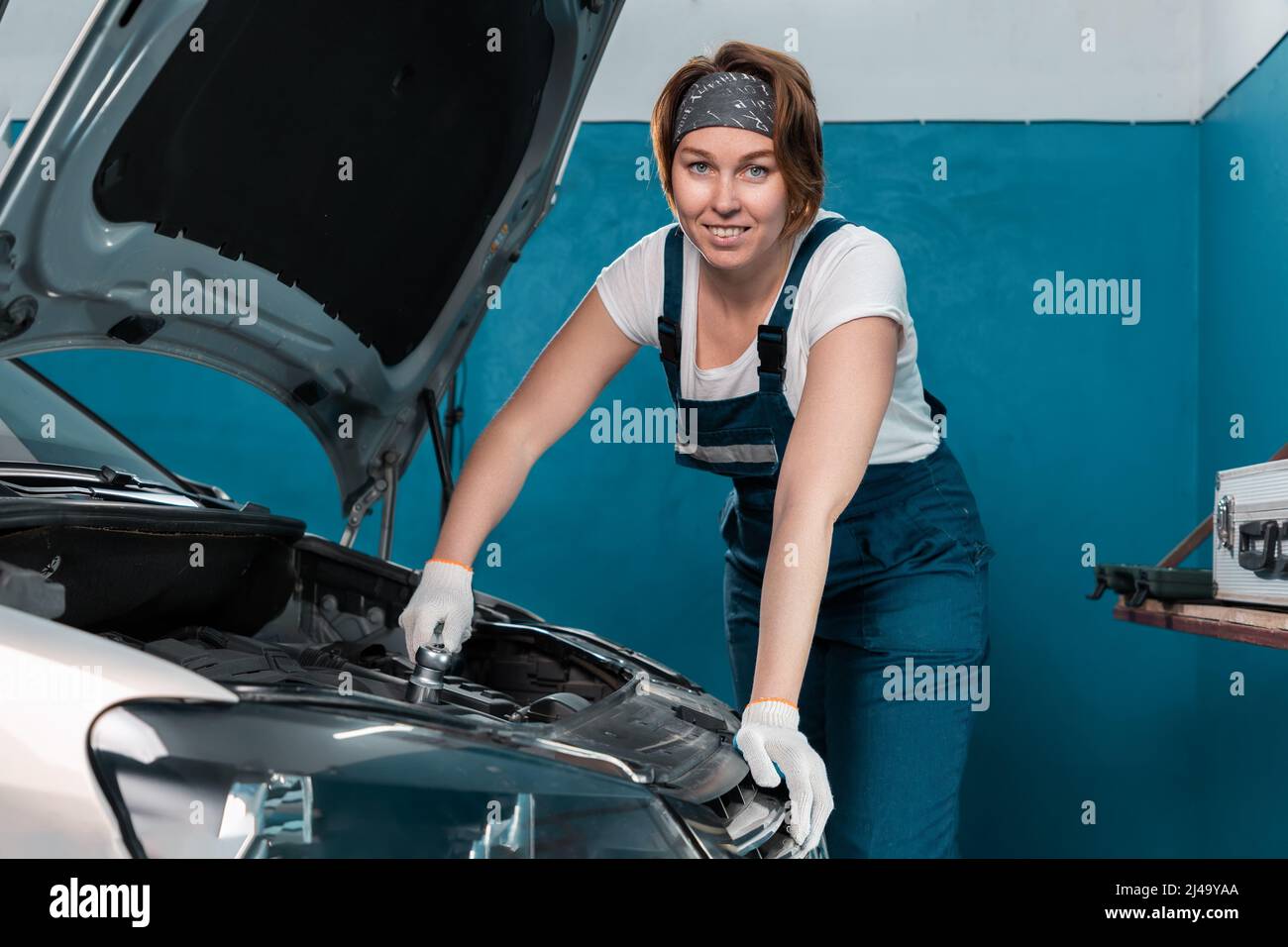 Sorridente meccanico donna in guanti ripara auto con chiave. Il concetto di  parità delle donne Foto stock - Alamy