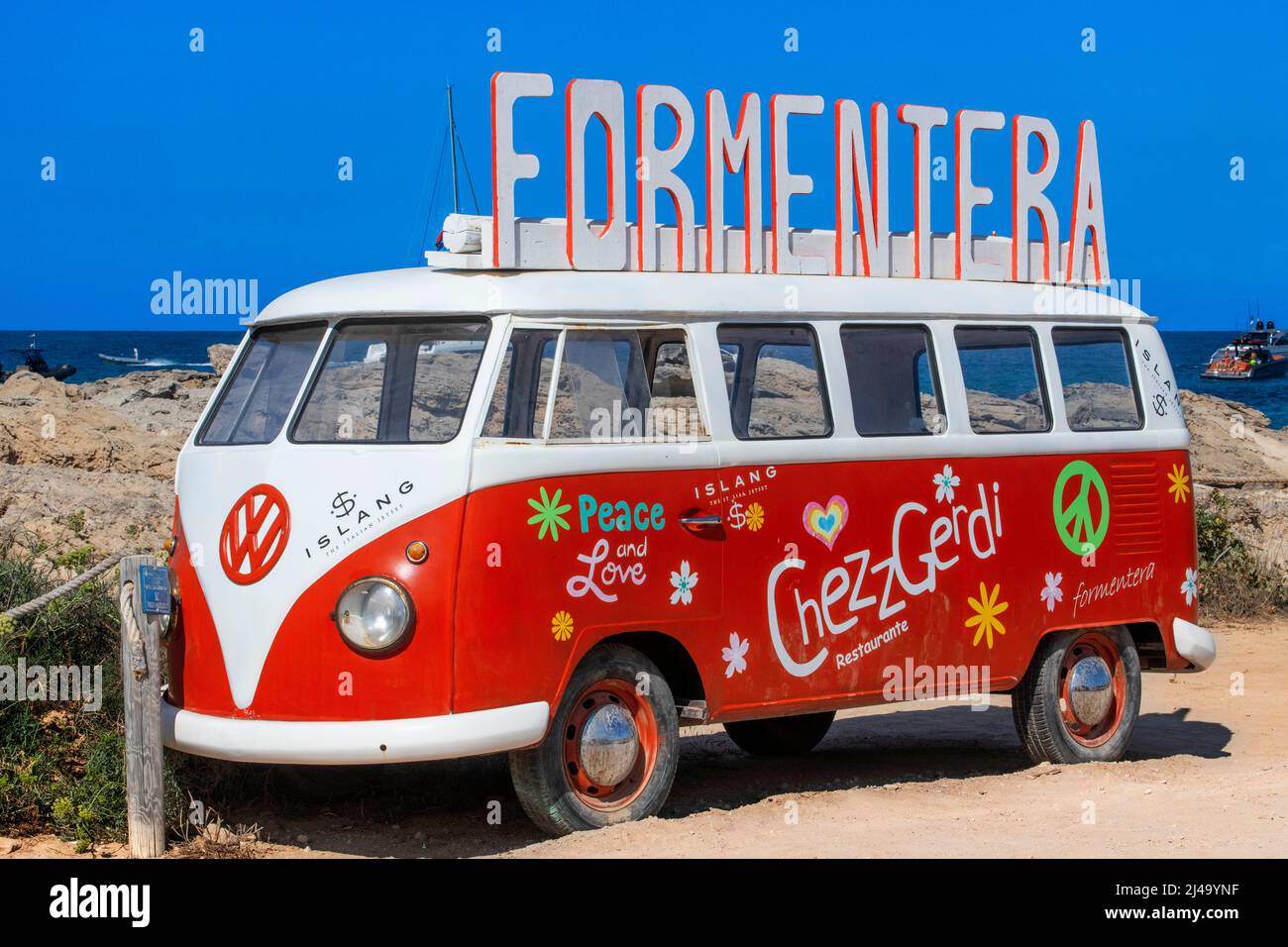 Classic Volkswagen rosso e bianco tipo 2 camper van sulla spiaggia es Pujols, Cheszz Gerdi bar spiaggia ristorante pubblicità, Balearis Isole, Formentera, Spa Foto Stock