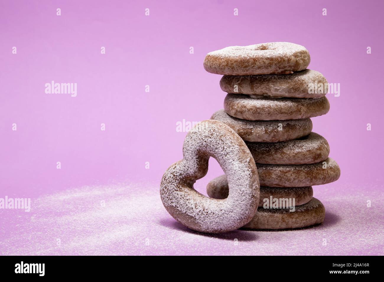 Biscotti impilati a forma di cuore di pan di zenzero su sfondo viola Foto Stock