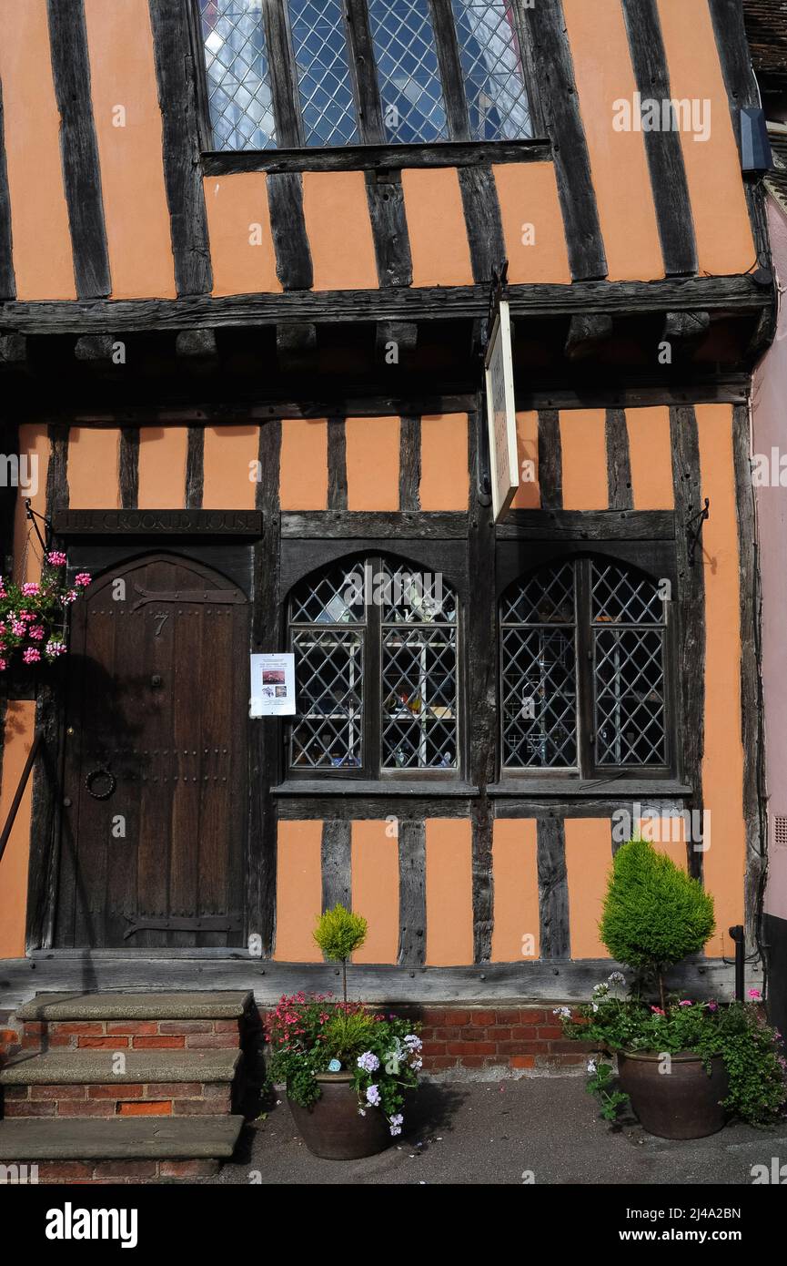 La Crooked House, con il suo piano superiore e il suo tetto a spioventi drammaticamente a sinistra, è uno dei più antichi edifici incorniciati in legno nella vecchia città di lana e stoffa di Lavenham, a Suffolk, Inghilterra, Regno Unito. Fu costruita nella High Street intorno al 1395, sotto il regno di re Riccardo II, come parte di una casa medievale. Si dice che la casa abbia ispirato la vecchia filastrocca iniziando: 'C'era un uomo storto, ha camminato un miglio storto ....'. Foto Stock