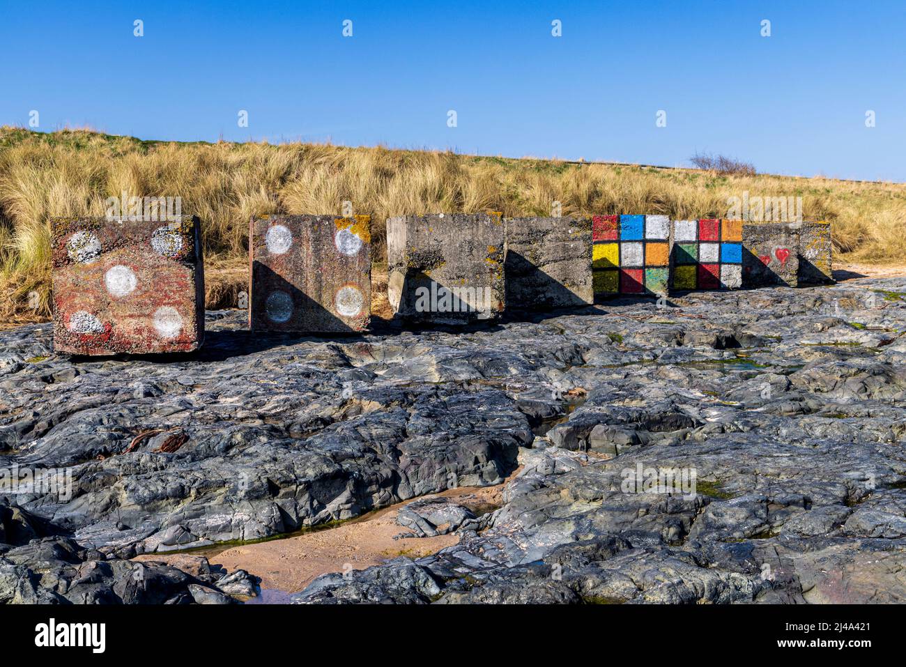 Cubi anticarro dipinti della seconda guerra mondiale a Bambburgh Beach, Northumberland Coast Path, Inghilterra Foto Stock