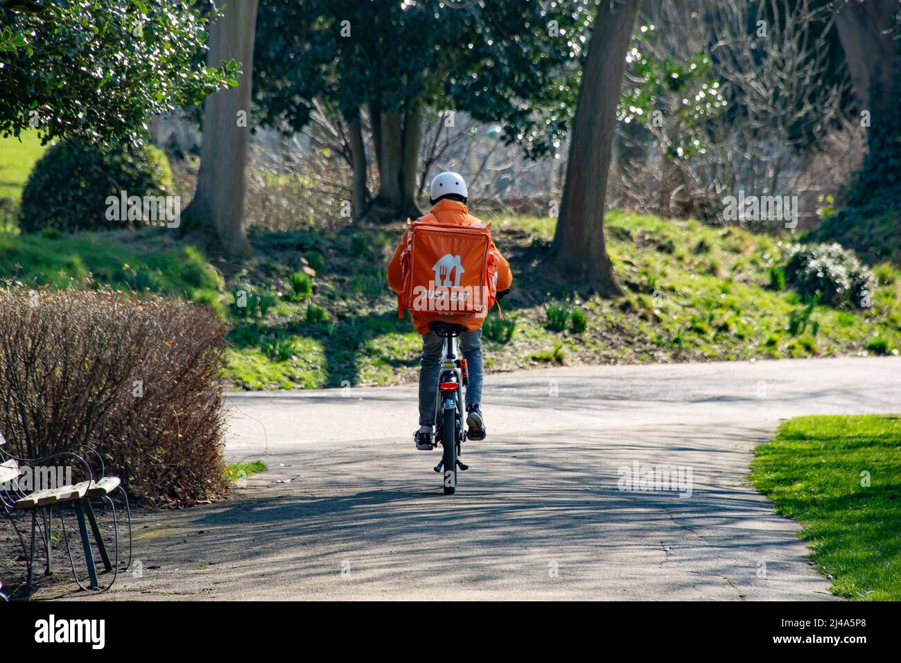 Basta mangiare il conducente di consegna in bicicletta, Victoria Park, Londra, Regno Unito. Foto Stock