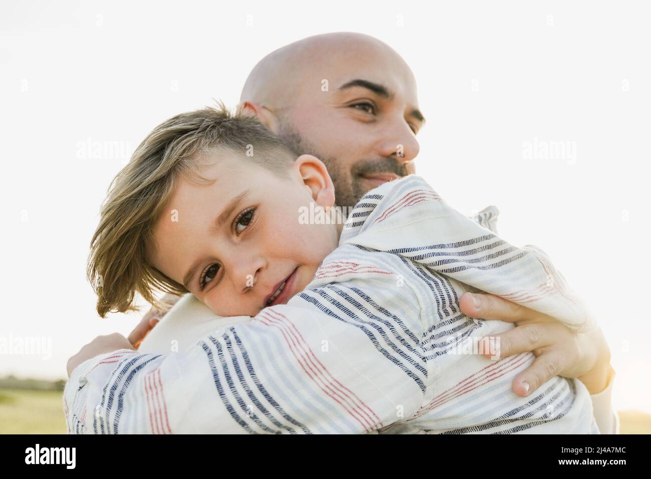 Padre e figlio che hanno un momento tenero all'aperto durante le vacanze - Focus sul viso del bambino Foto Stock
