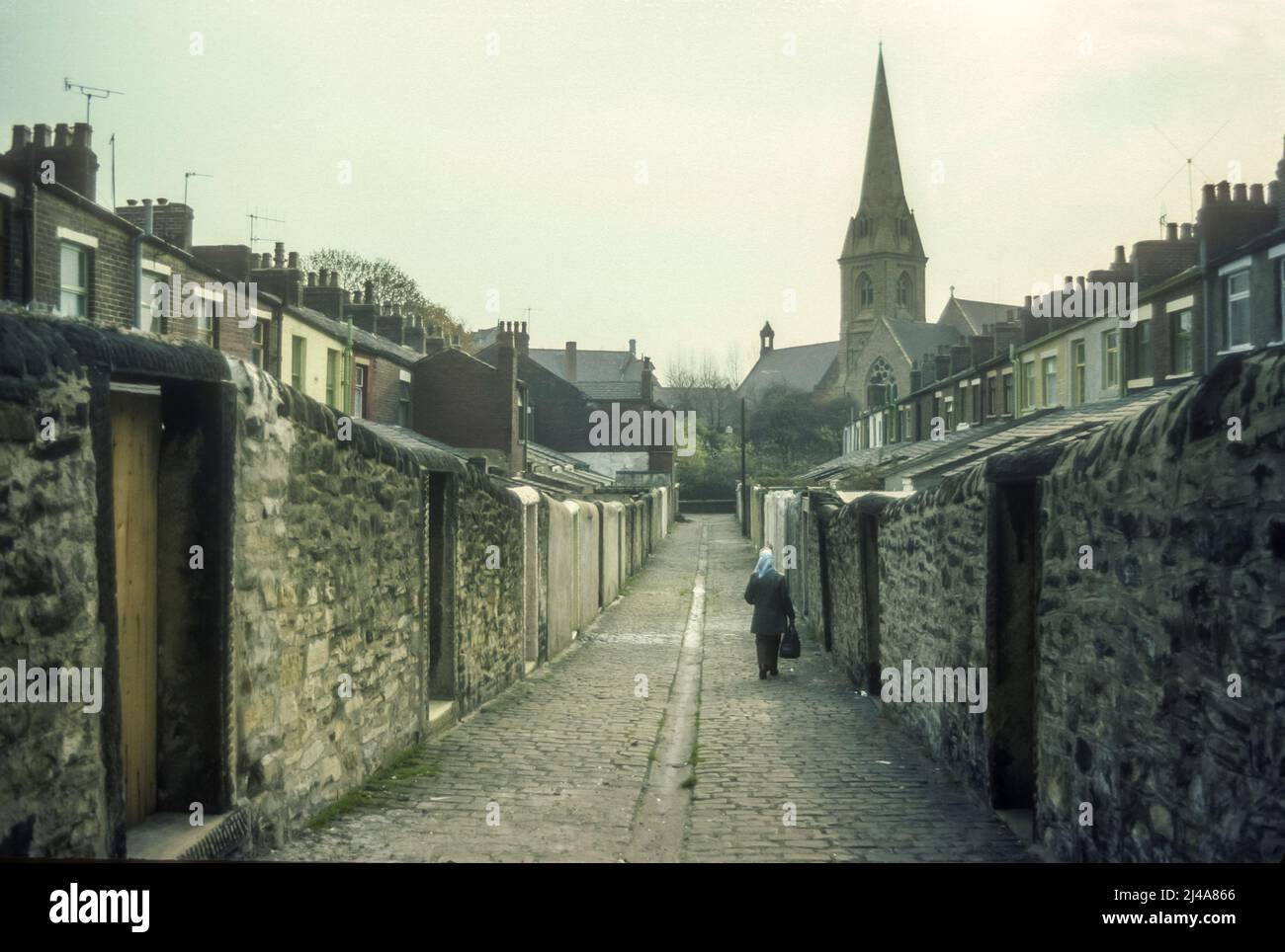 1970s immagine d'archivio di case terrazzate e un vicolo acciottolato a Blackburn, Lancashire. Foto Stock