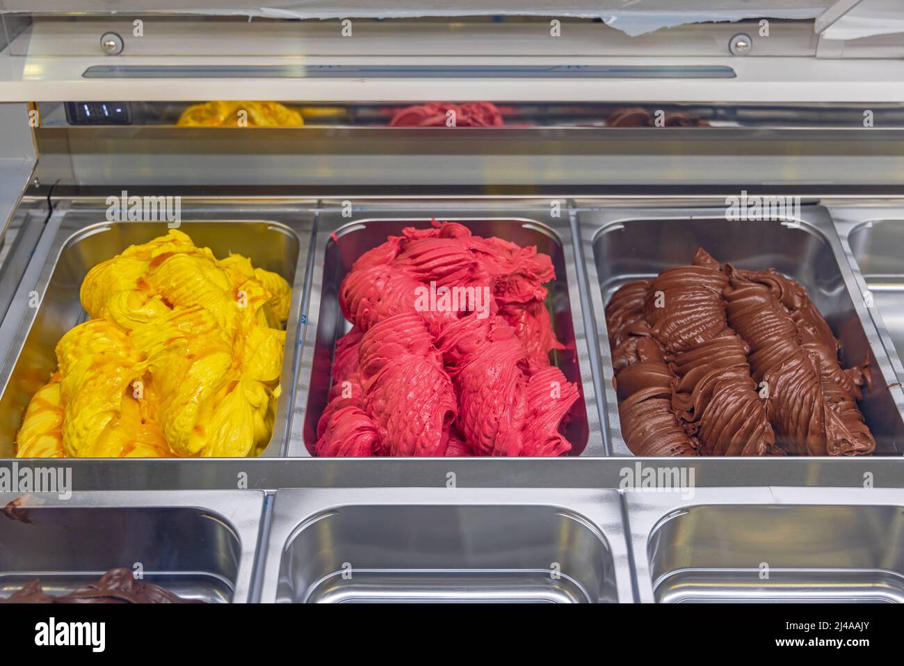 Vari sapori gelato in grandi vasche Display Freezer Foto Stock