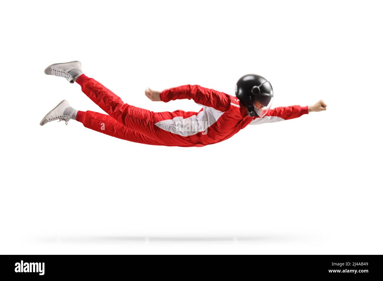 Pilota di auto in un abito rosso e casco nero volare isolato su sfondo bianco Foto Stock