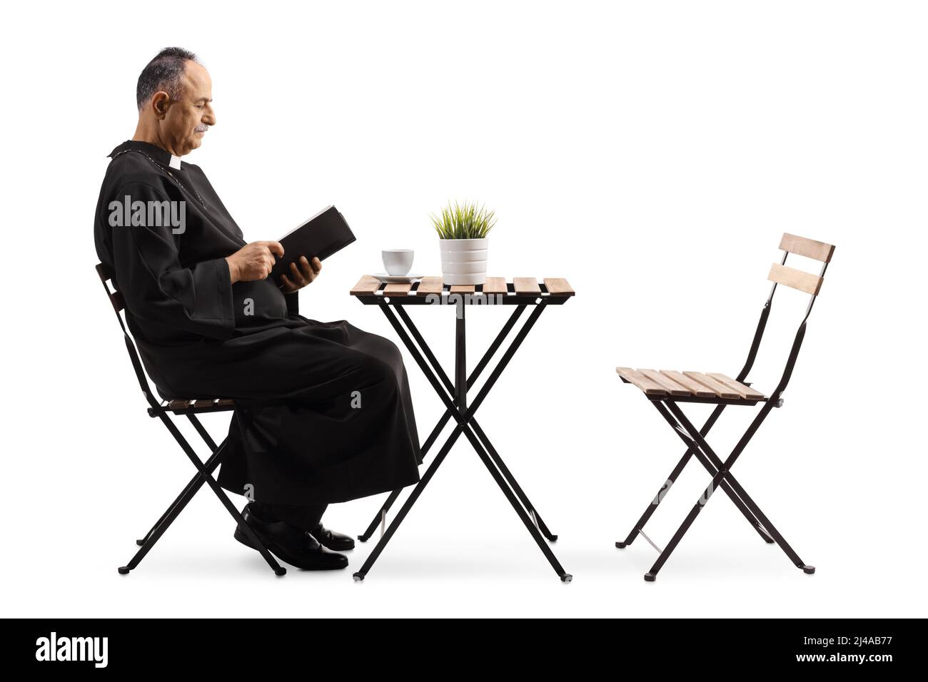 Profilo girato di un sacerdote che legge la bibbia in un caffè isolato su sfondo bianco Foto Stock