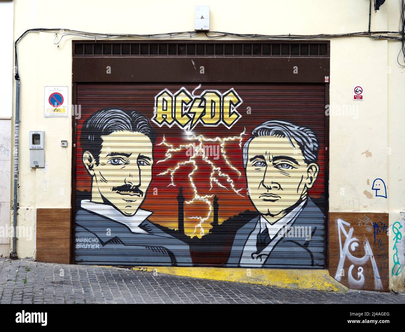 Graffiti a Siviglia, Spagna, con 2 uomini e logo AC/DC Foto Stock