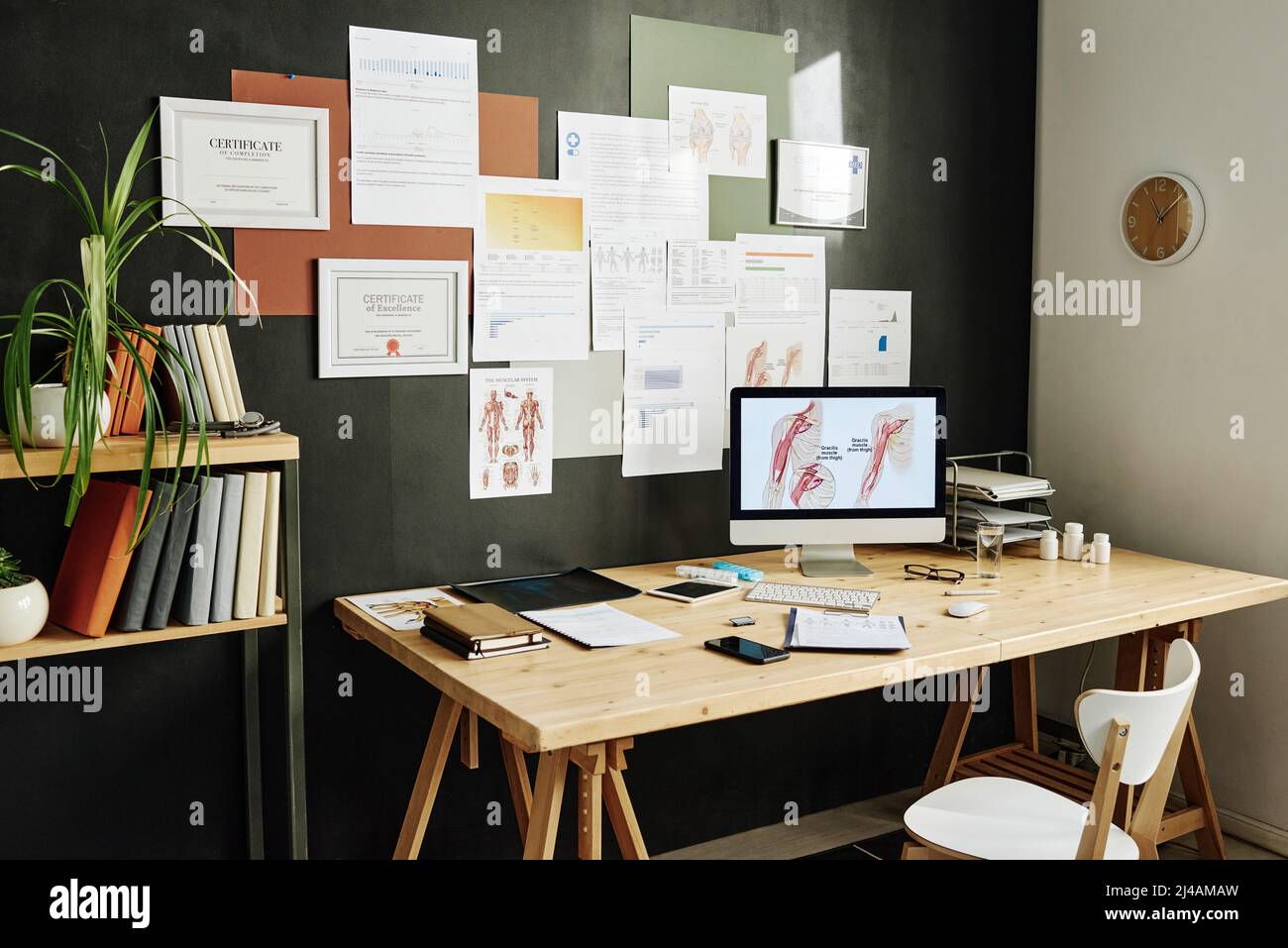 Immagine del moderno luogo di lavoro del medico con monitor per computer e certificati a parete Foto Stock