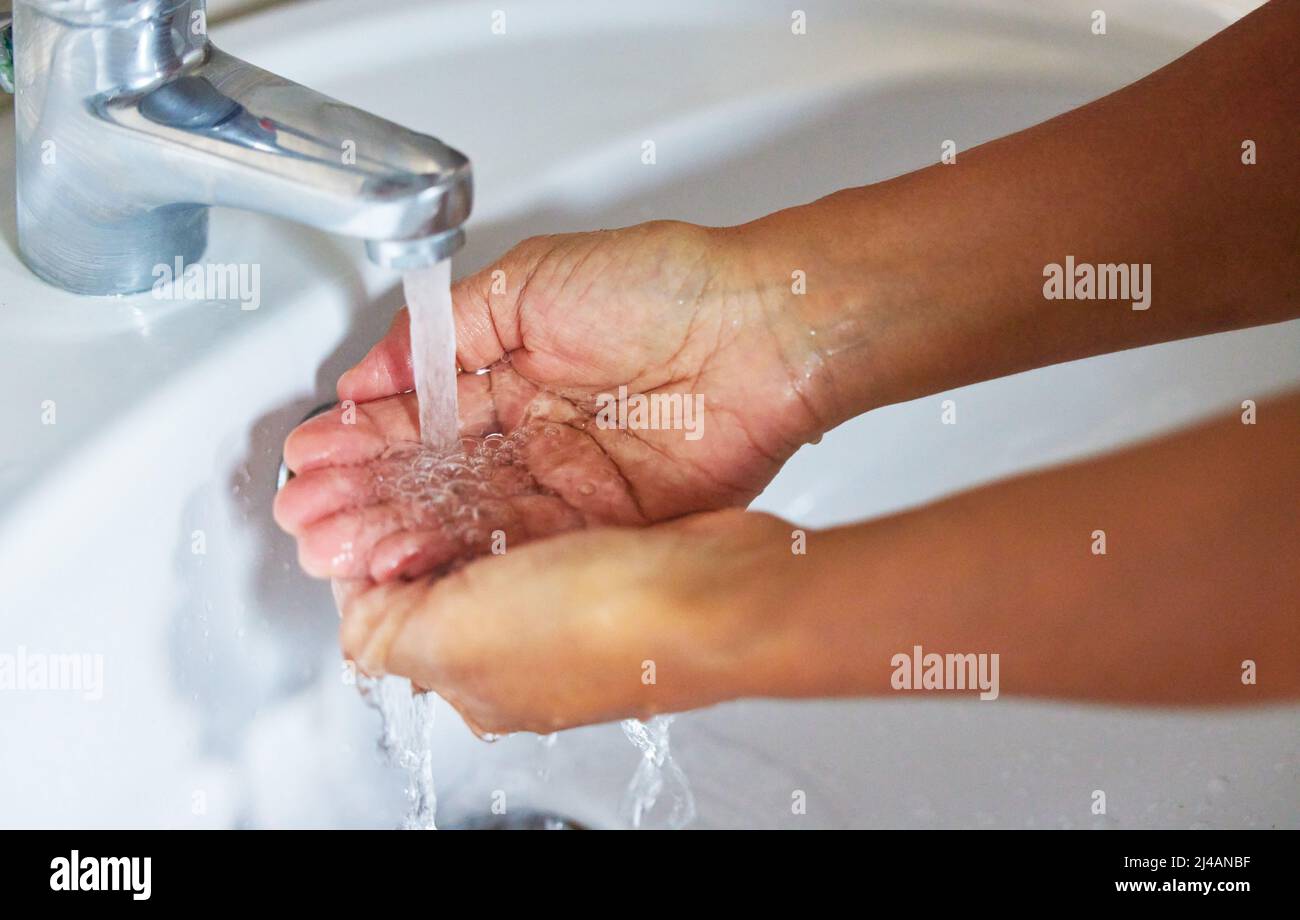 Conosca il valore di acqua prima che tutti i pozzi corrano asciutto. Scatto corto di un maschio irriconoscibile lavando le mani in un lavabo a casa. Foto Stock