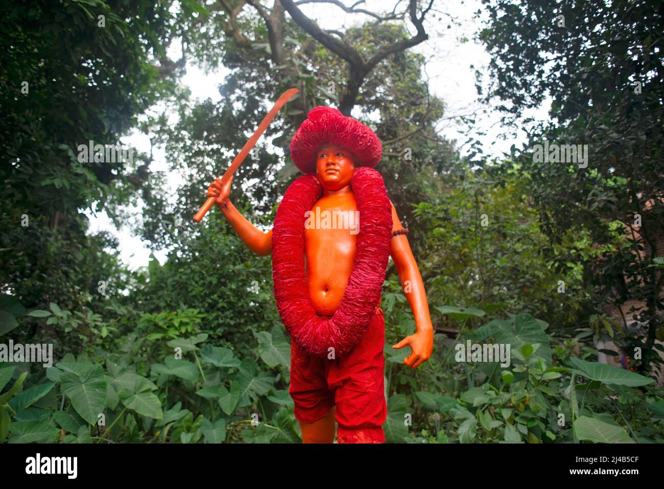 Munshiganj, Bangladesh. 13th Apr 2022. Un devoto indù che partecipa ad una processione di Lal Kach pone per una foto con la sua spada. Il festival Lal Kach (Galls Rosso) viene celebrato nella comunità locale per molti decenni. Gli uomini indù si dipingono di colore rosso e assistono ad una processione che tiene spade mentre mostrano il potere contro gli sprit malvagi mentre concludono un anno ed accolgono un altro nuovo anno nuovo di Bangla. (Foto di Ziaul Haque Oisharjh/SOPA Images/Sipa USA) Credit: Sipa USA/Alamy Live News Foto Stock