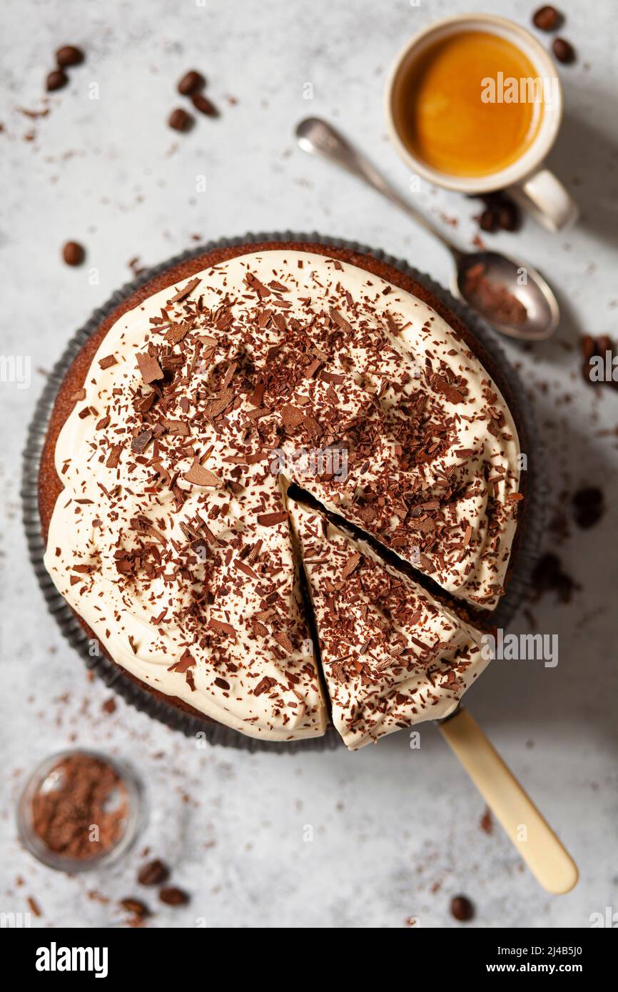 Una torta al caffè irlandese con panna montata e cioccolato grattugiato. Una fetta è stata tagliata ed è pronta per servire. Foto Stock