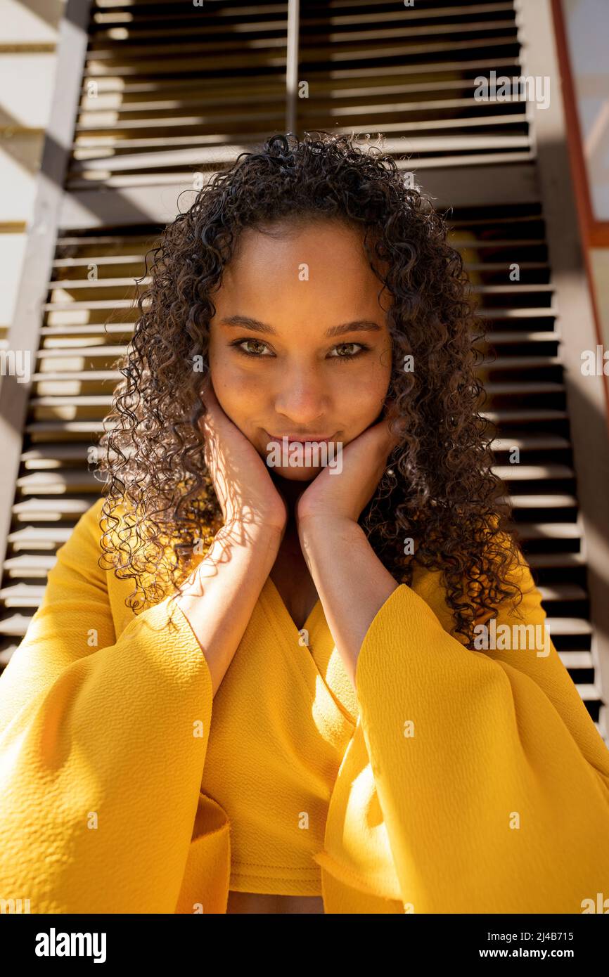 Ritratto di una giovane donna nera colorata in piedi di fronte agli otturatori vittoriani Foto Stock