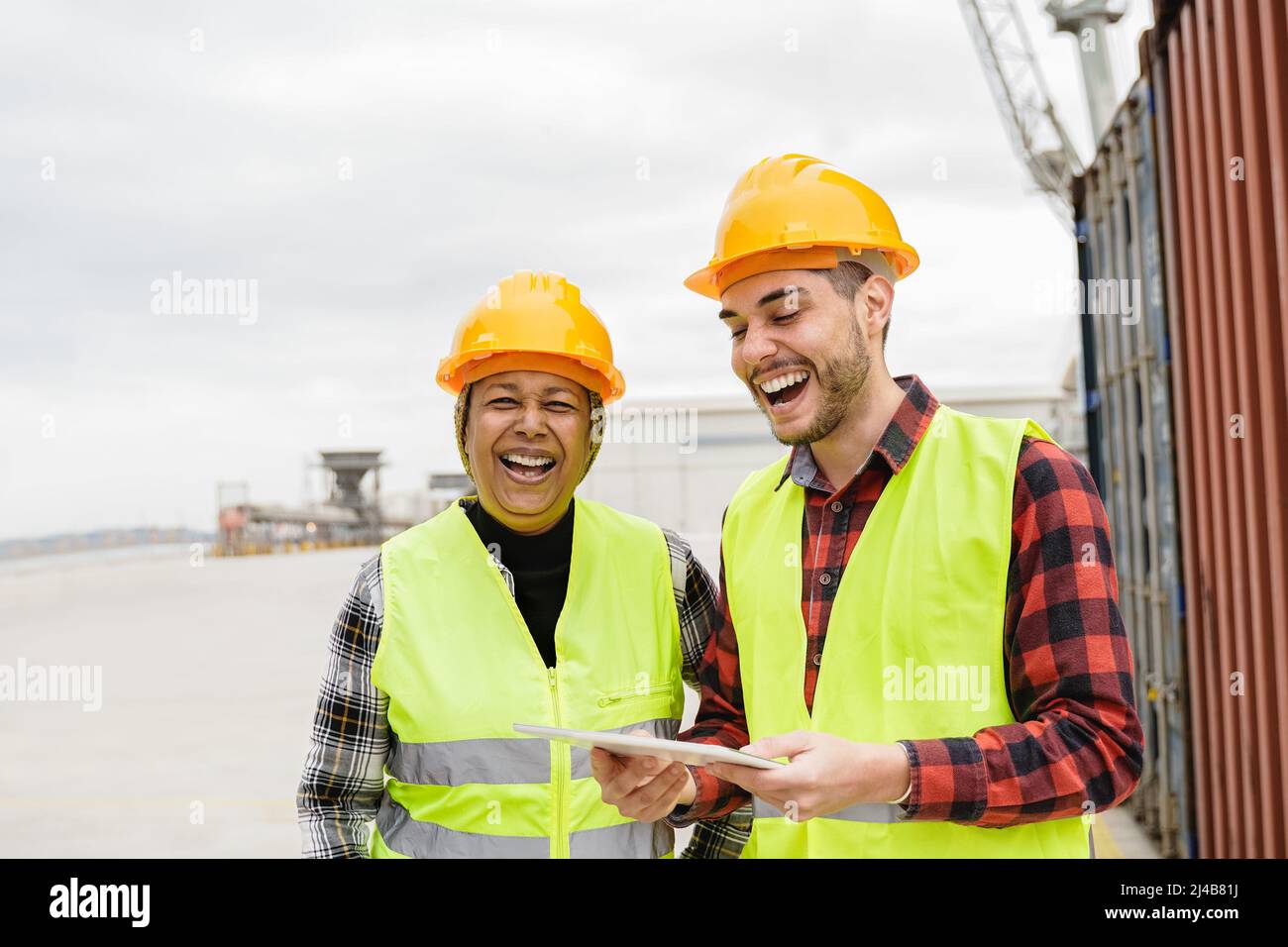 Lavoratori industriali multigenerazionali che si divertono a spedire container terminal portuale - operazioni di logistica merci - Focus on african senior woman f Foto Stock