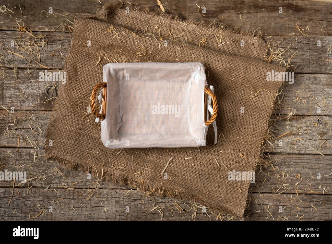 Svuotare il cestino del pane con un tovagliolo bianco su un panno di tela coperta di paglia Foto Stock