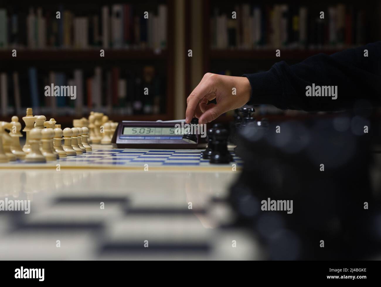 mano che muove una pedina in un gioco di scacchi. Foto Stock