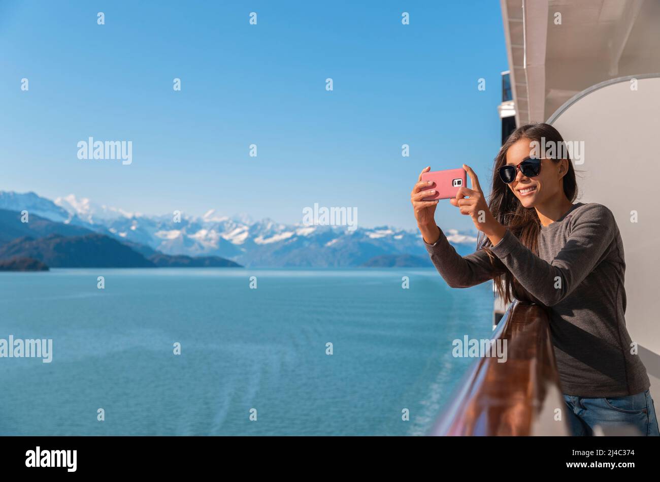 Alaska Glacier Bay crociera nave di viaggio turistico guardando icebergs scattare foto utilizzando il telefono in passaggio interno dal terrazzo balcone. Crociera panoramica Foto Stock