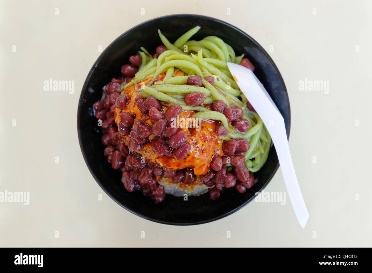 Il Cendol è un dolce fatto con ghiaccio rasato e gelatina di farina di riso verde, latte di cocco e sciroppo. Foto Stock
