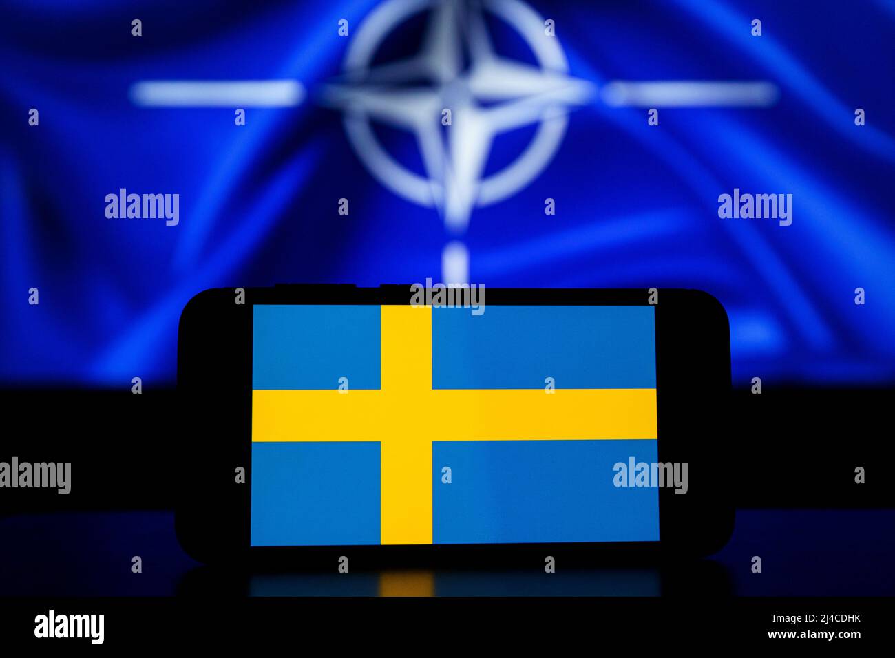 L'Organizzazione del Trattato del Nord Atlantico sugli schermi. Bandiera della Svezia sullo schermo e bandiera della NATO sullo sfondo Foto Stock