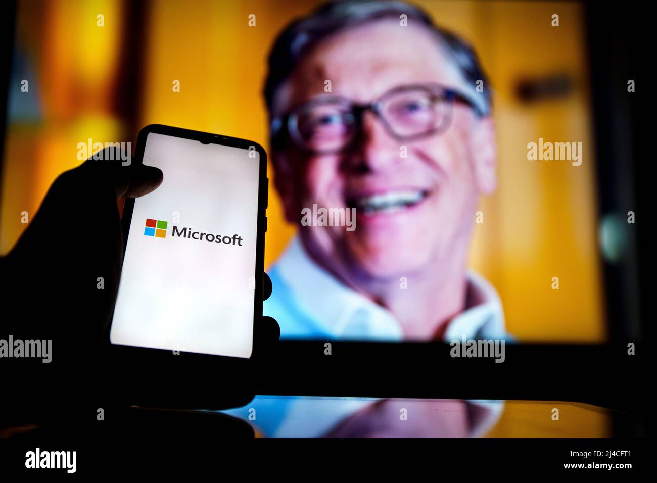 Logo Microsoft sullo schermo e Bill Gates sullo sfondo. È co-fondatore di Microsoft Foto Stock