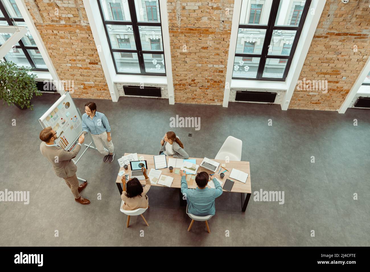 Due persone che scuotono le mani durante una riunione in ufficio Foto Stock