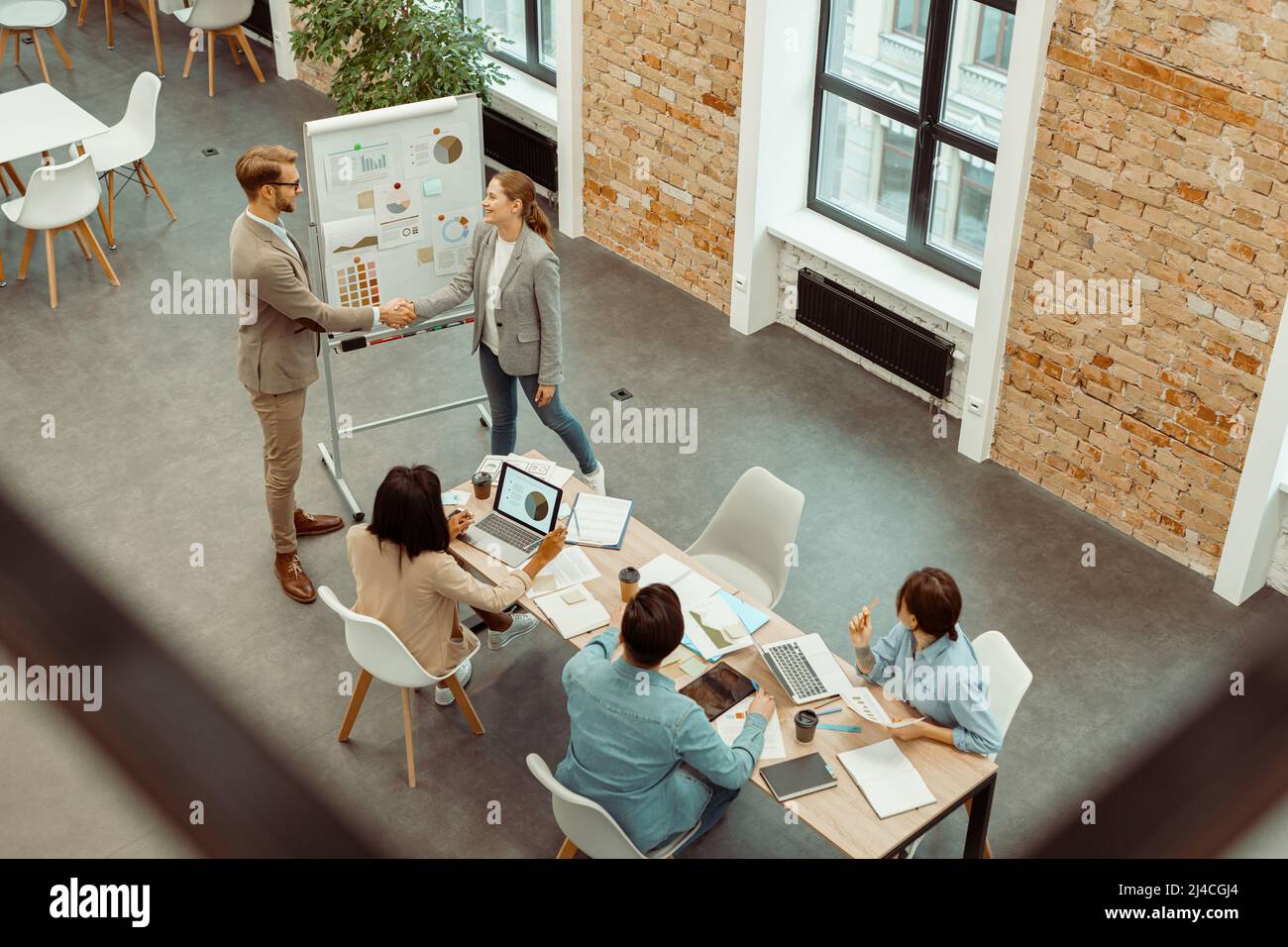 Due colleghi si scuotono le mani durante una riunione in ufficio Foto Stock
