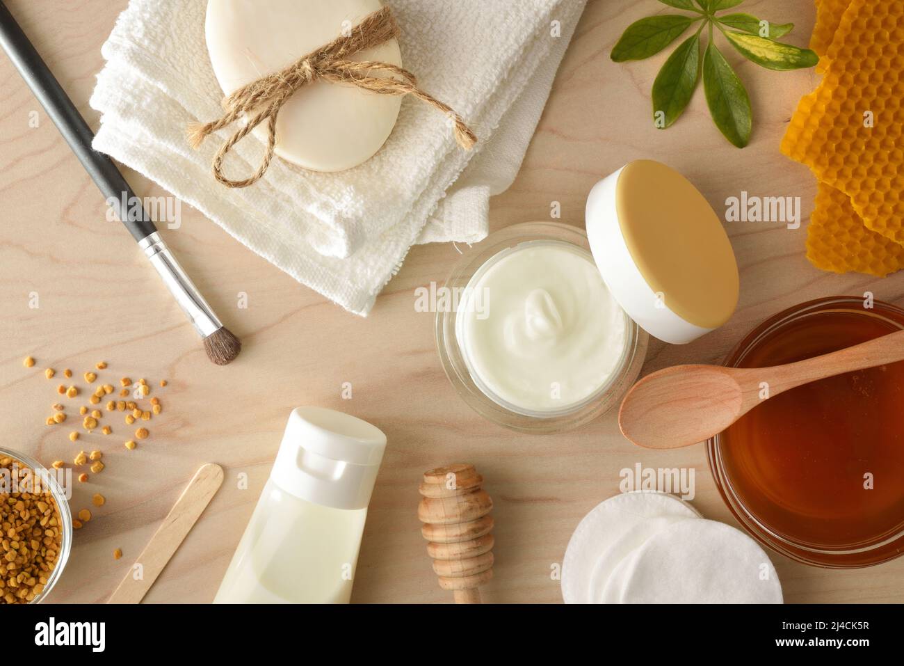 Cosmetici con estratti di miele con attrezzi e prodotti da bagno su tavola di legno. Composizione orizzontale. Vista dall'alto. Foto Stock