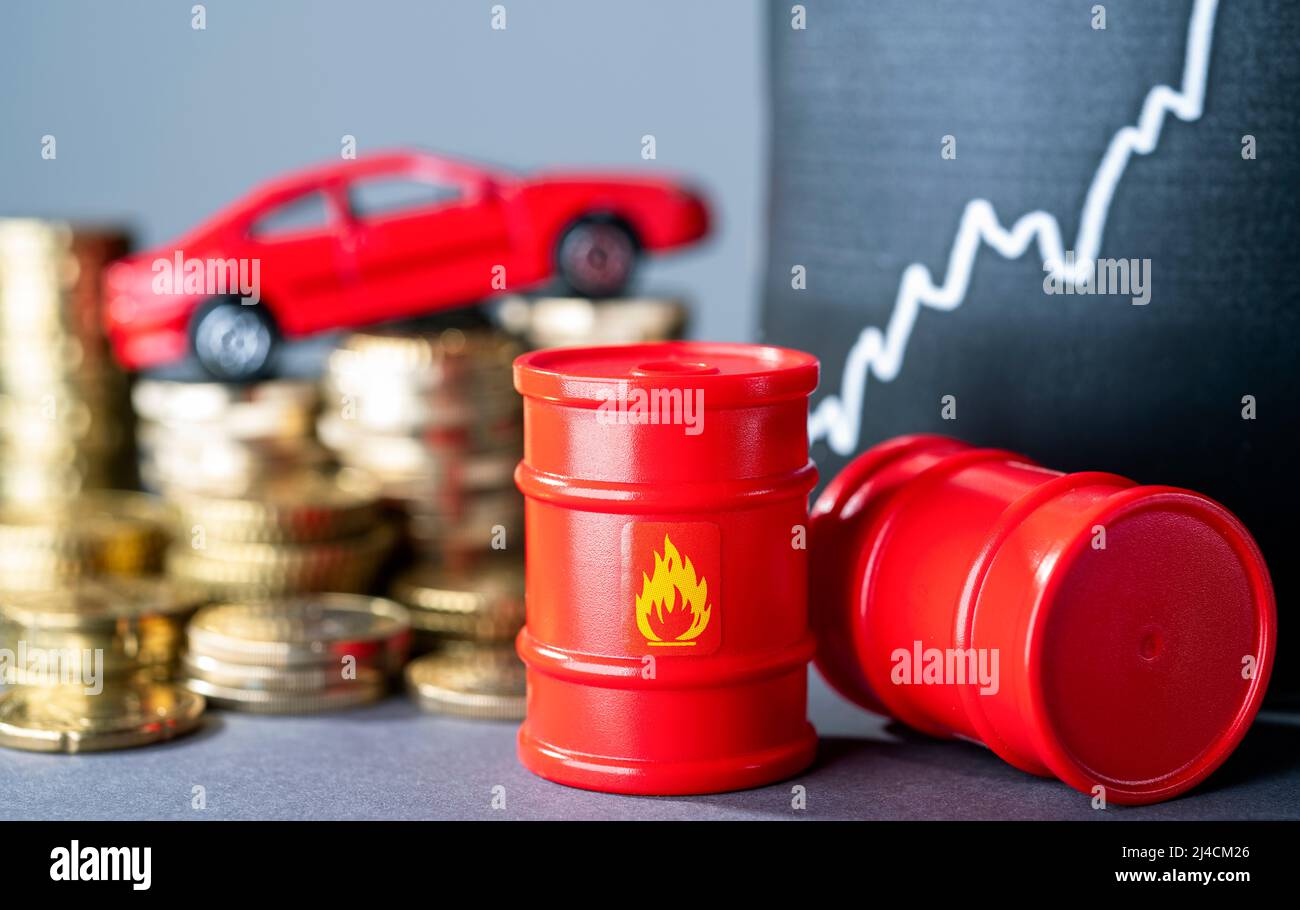 Barili rossi e auto, pile di denaro e una curva crescente che simboleggia i prezzi elevati del carburante Foto Stock