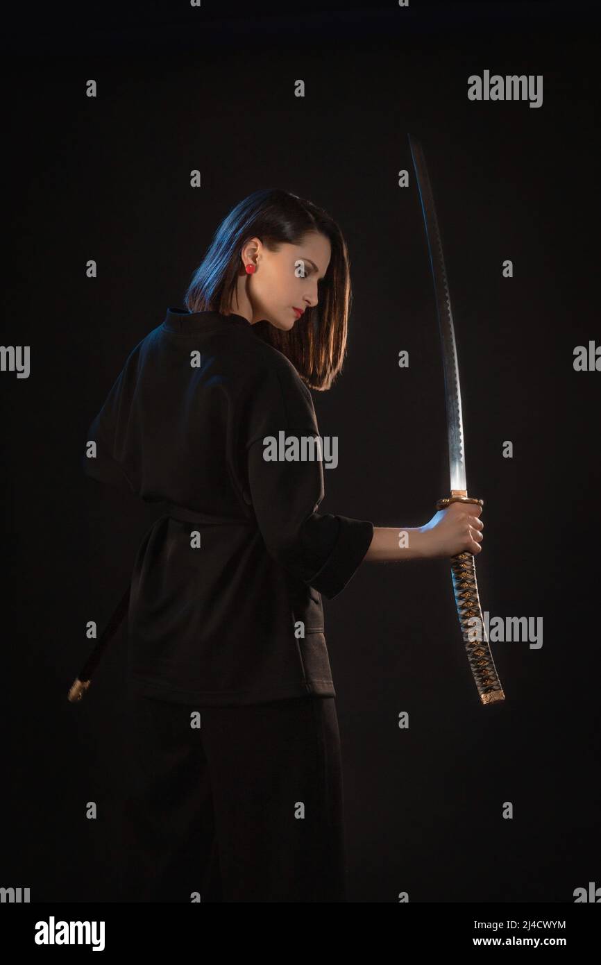 Misteriosa giovane bella donna con lama affilata in stile asiatico. Foto Stock