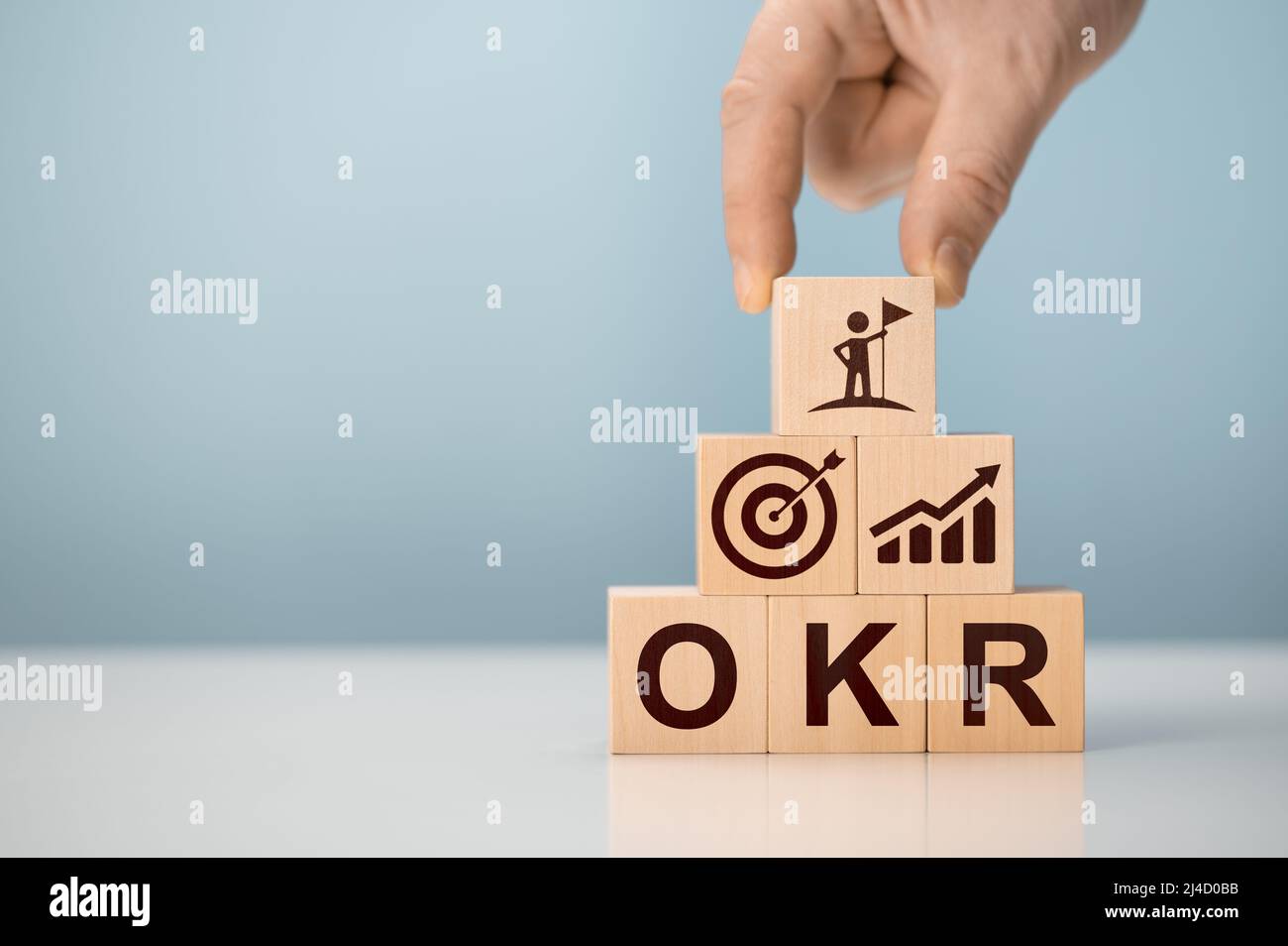 OKR obiettivi, chiave e risultati blocchi di cubo di legno su sfondo blu. Obiettivo aziendale e promuovere il business e le prestazioni. Concentrarsi sull'obiettivo. Progetto mana Foto Stock