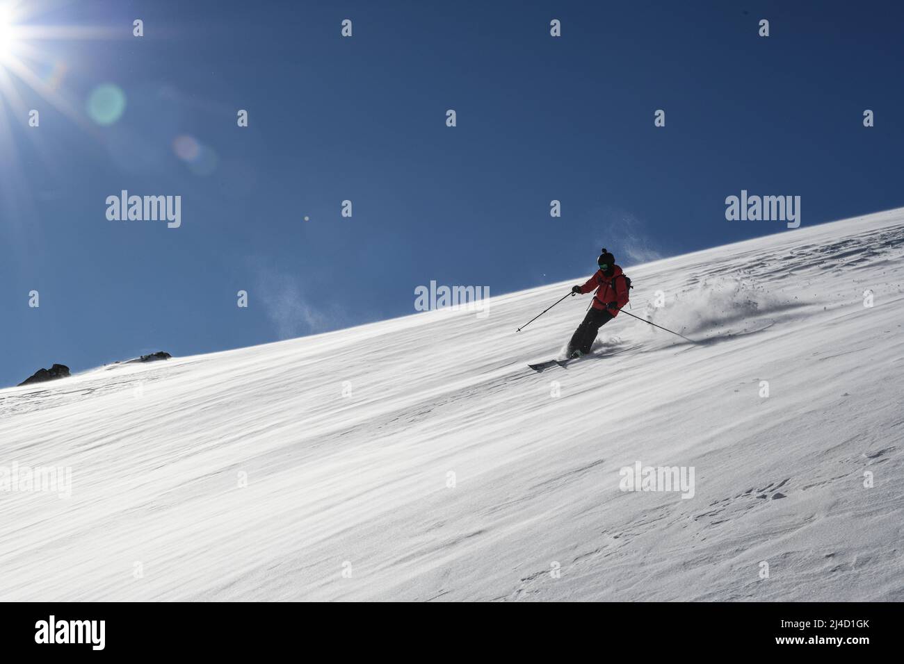 Sciatore che naviga lungo una montagna polverosa Foto Stock Sciatore che naviga lungo una montagna polverosa Foto Stock